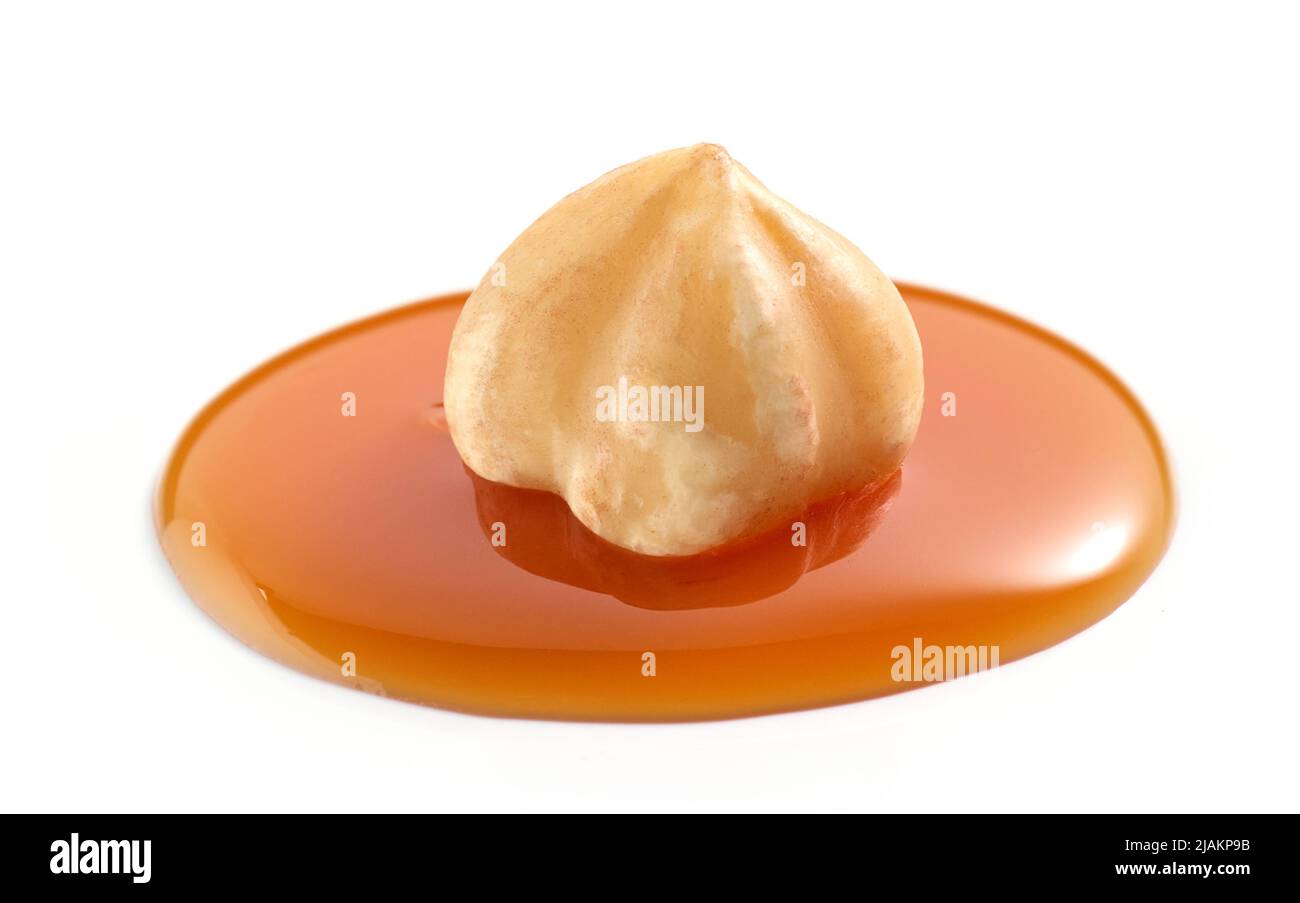noisette en goutte de sauce caramel fondue isolée sur fond blanc Banque D'Images