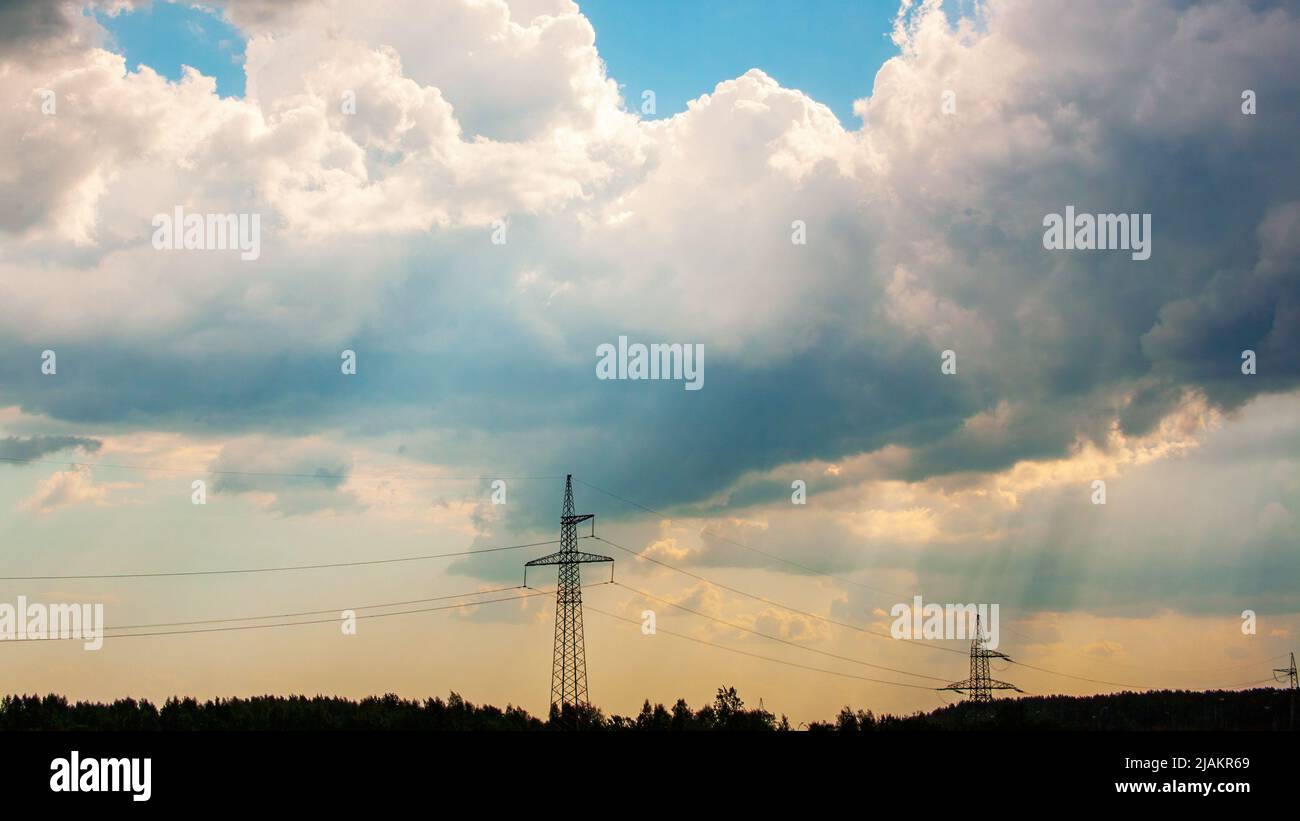 Mâts de ligne électrique contre un ciel orageux Banque D'Images