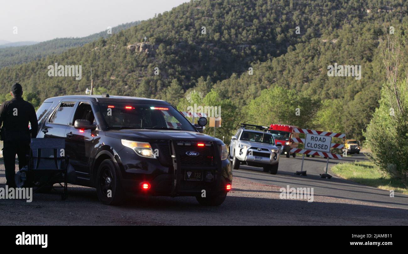 New Mexicoon 21 mai 2022, les camions d'incendie et le personnel quittent leurs positions stationnées dans le haut du canyon Pecos et se dirigent pour leur changement de quart au camp d'incendie voisin situé dans la ville de Pecos. Un officier de la patrouille d'État du Nouveau-Mexique occupe un pâté de maisons pour empêcher tous les combattants sauf les pompiers de monter sur la route du canyon, New Mexico State Highway 63. (Photo de Steve Clevenger/Sipa USA) Banque D'Images