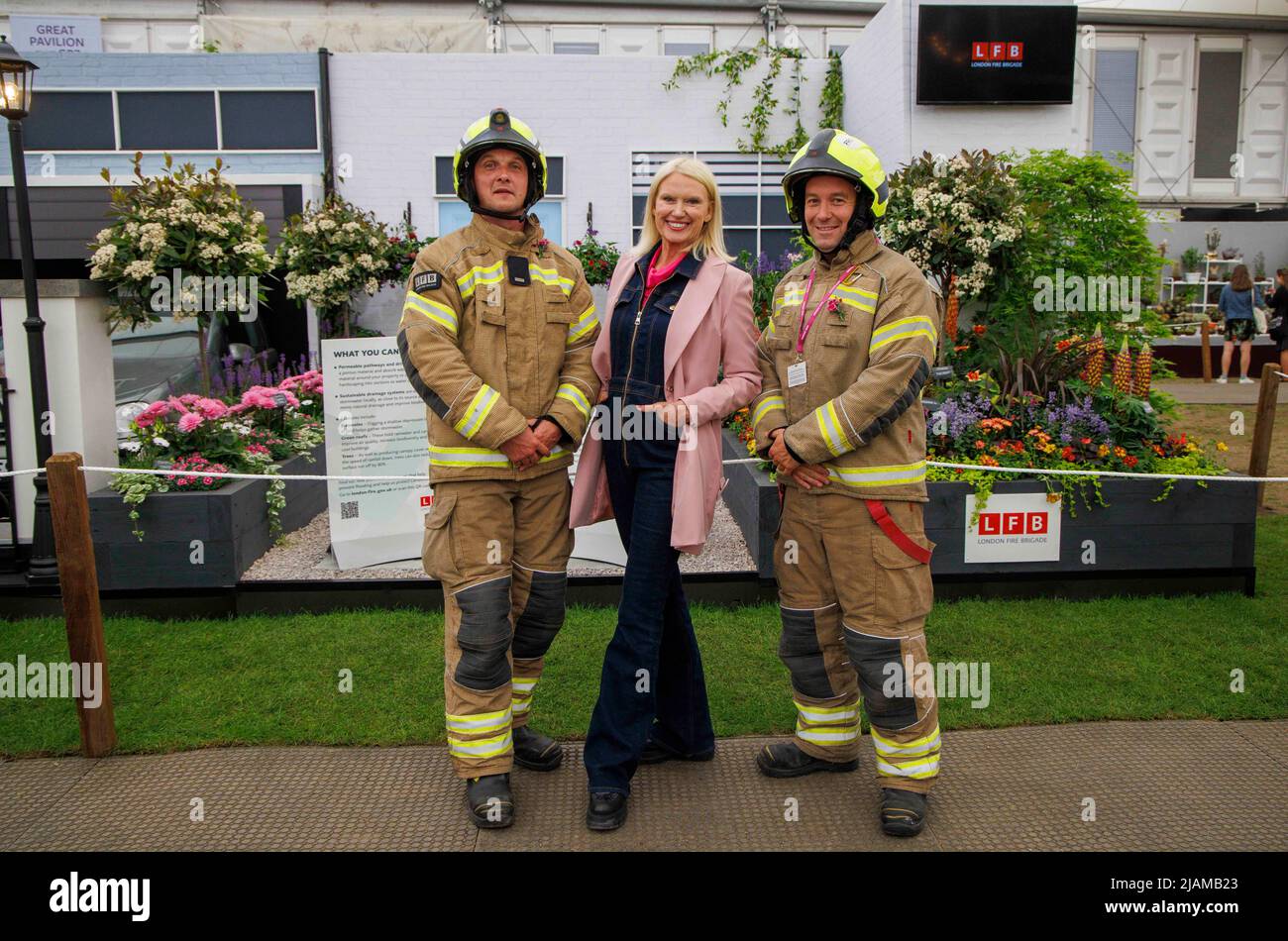 Anneka Rice, présentatrice, écrivain et journaliste à la télévision, au RHS Chelsea Flower Show avec deux pompiers à l'exposition des pompiers. Banque D'Images