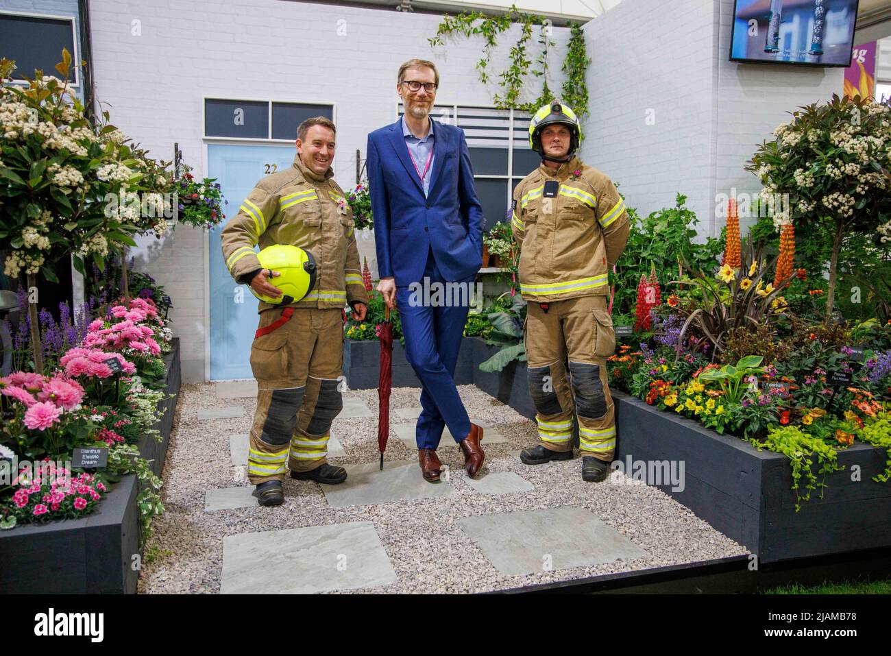 Stephen Merchant, acteur, comédien, réalisateur, présentateur et écrivain, Au RHS Chelsea Flower Show avec deux pompiers. Banque D'Images