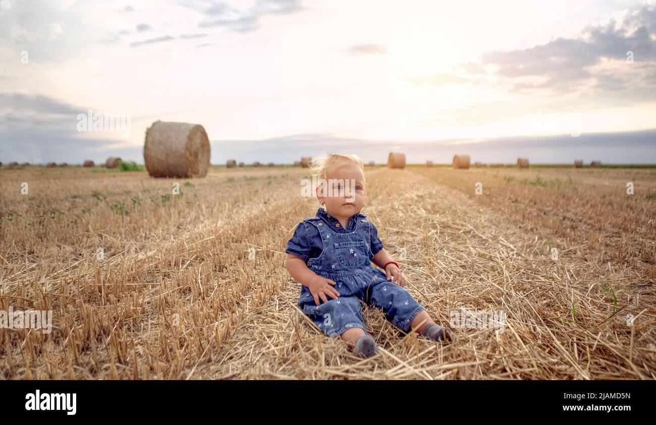 Petite fille dans le champ de blé.petite fille souriante et heureuse. La nature dans le pays Banque D'Images