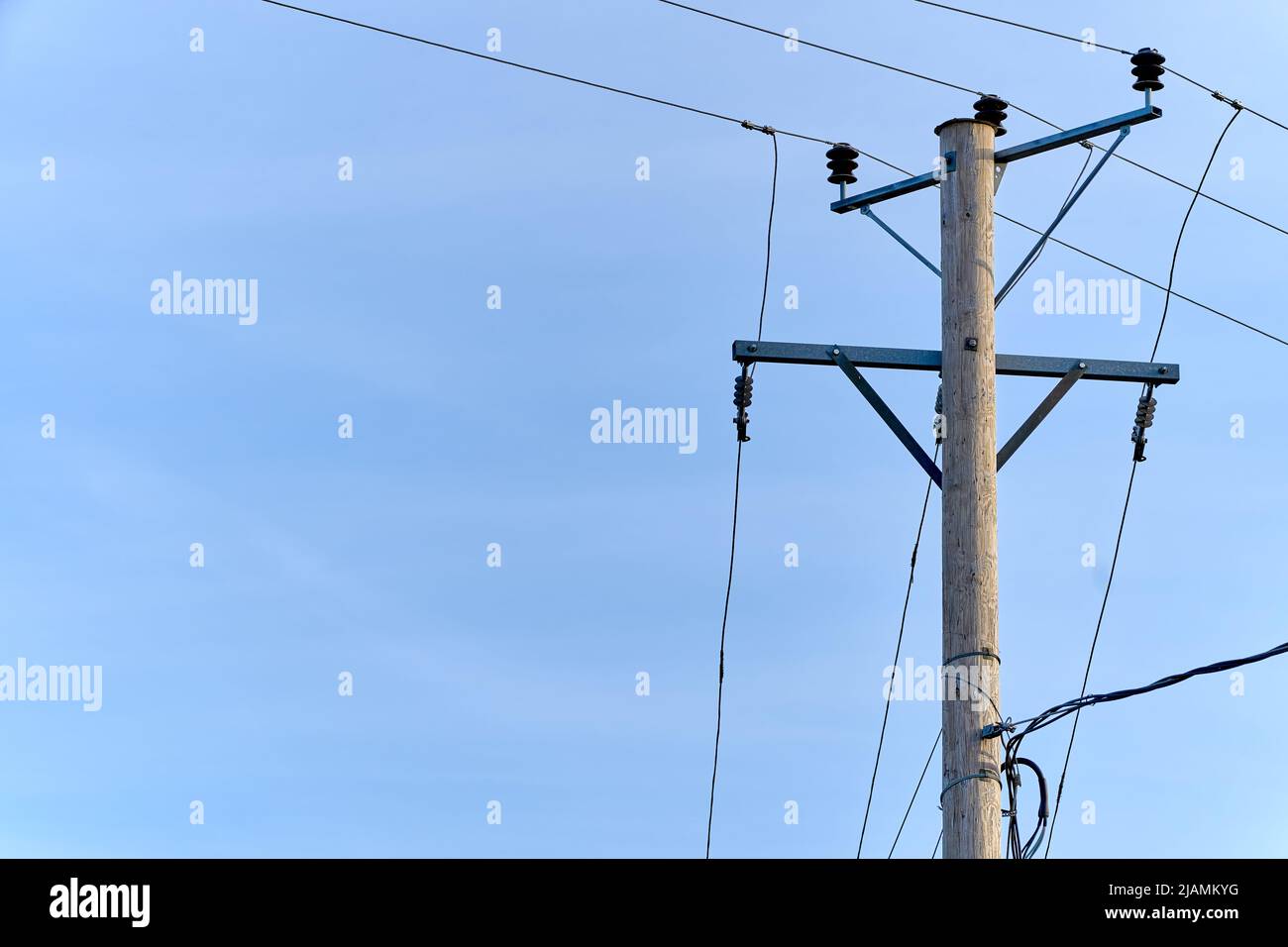 Un ancien mât électrique en bois lignes et fils électriques avec fond bleu ciel Banque D'Images