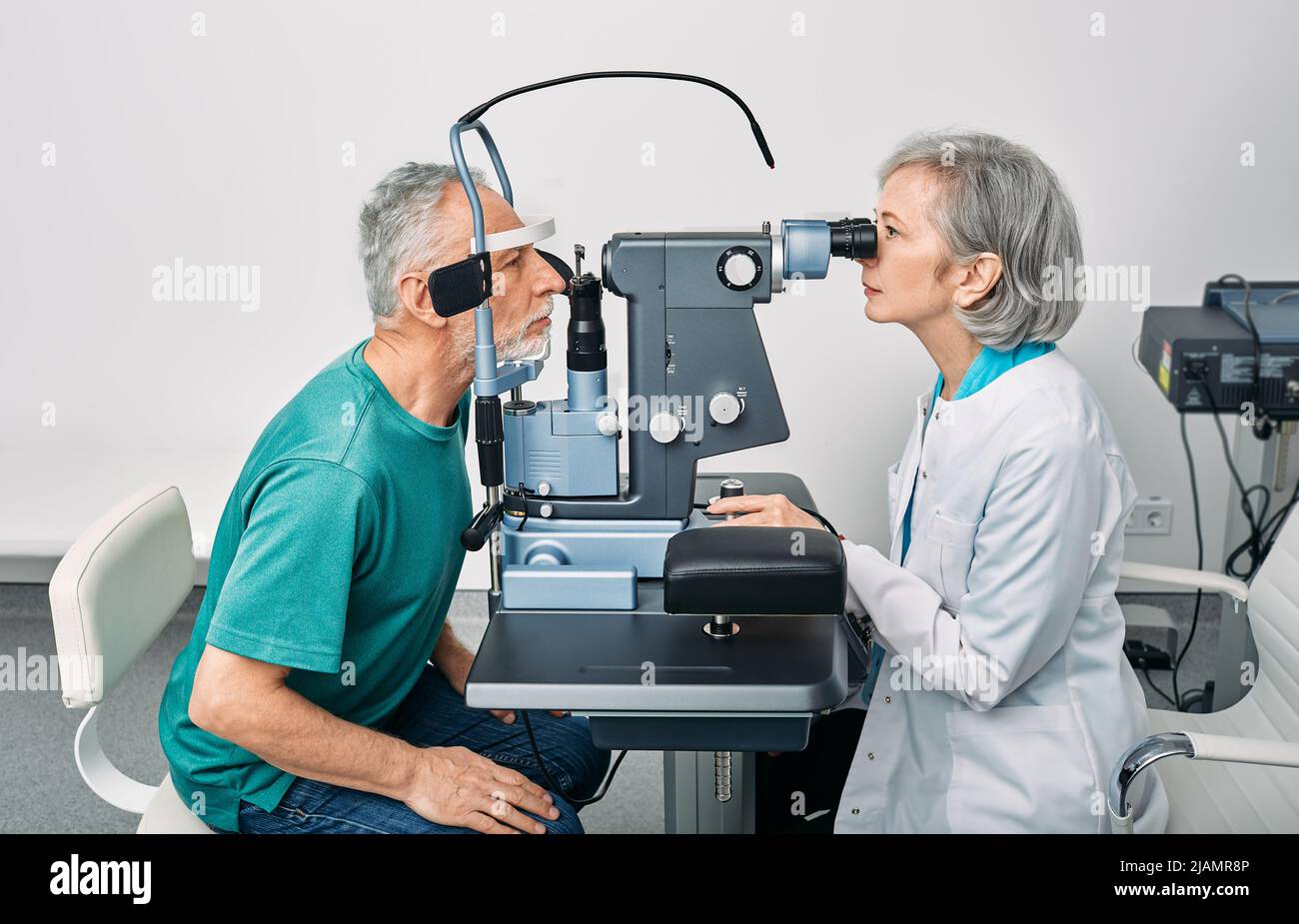 Examen oculaire et diagnostic de la vision. Optométriste féminin effectuant un test visuel pour un homme âgé à la clinique d'ophtalmologie moderne Banque D'Images