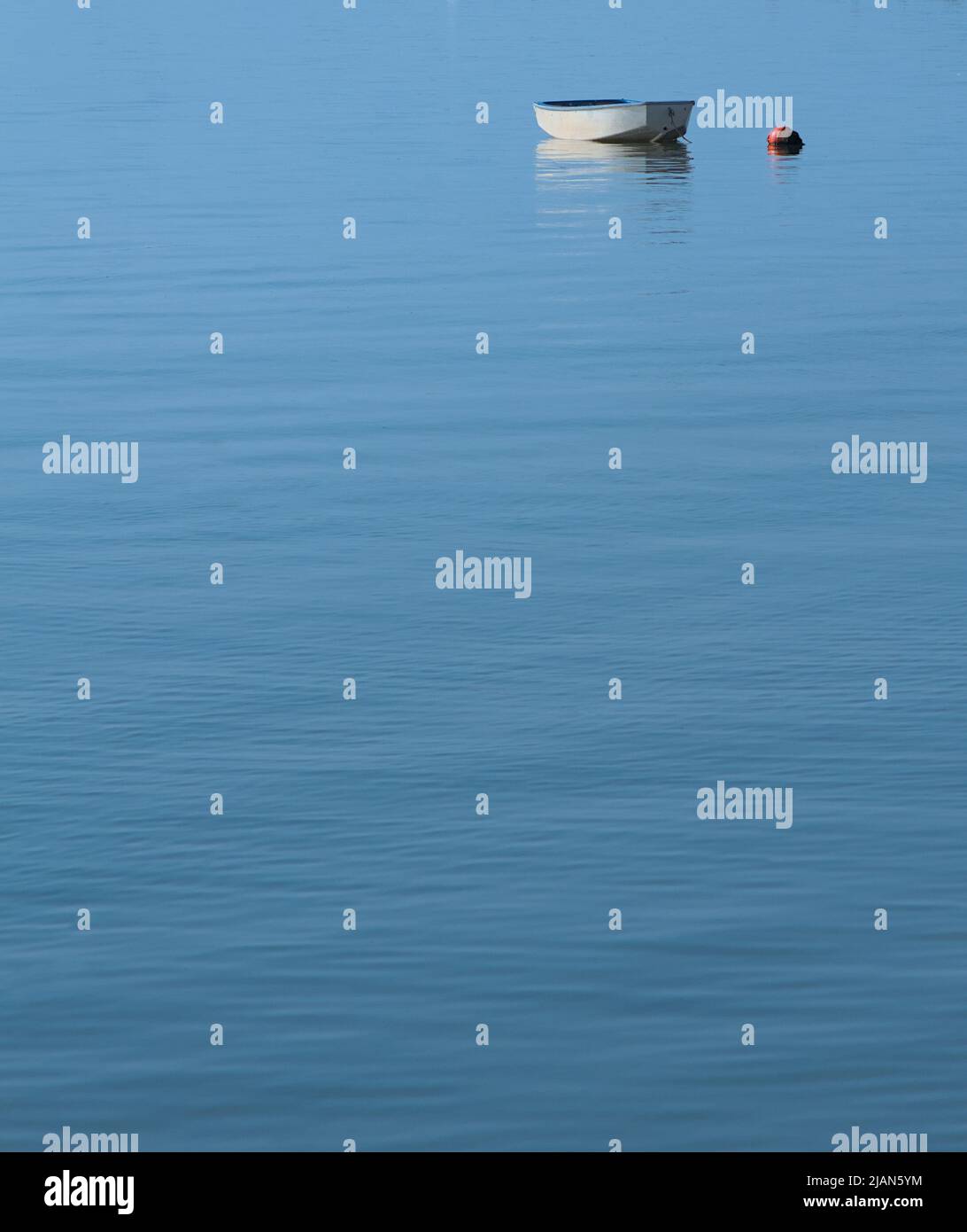 Single Tender, Dinghy, Boat and Mooing Buoy amarré sur le port de Christchurch lors D'Une journée calme avec STILL Water, Royaume-Uni Banque D'Images