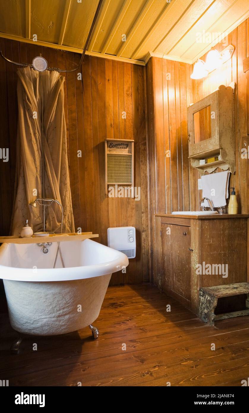 Baignoire sur pied blanche et mobilier ancien dans la salle de bains à  l'intérieur de la vieille maison en pierre de style cottage Canadiana  datant de 1840 Photo Stock - Alamy