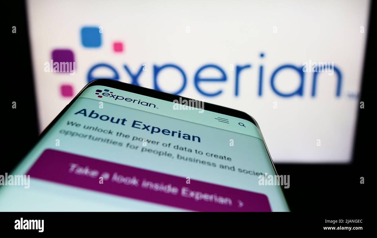 Smartphone avec le site Web de la société d'évaluation de crédit Experian plc à l'écran devant le logo de l'entreprise. Faites la mise au point dans le coin supérieur gauche de l'écran du téléphone. Banque D'Images