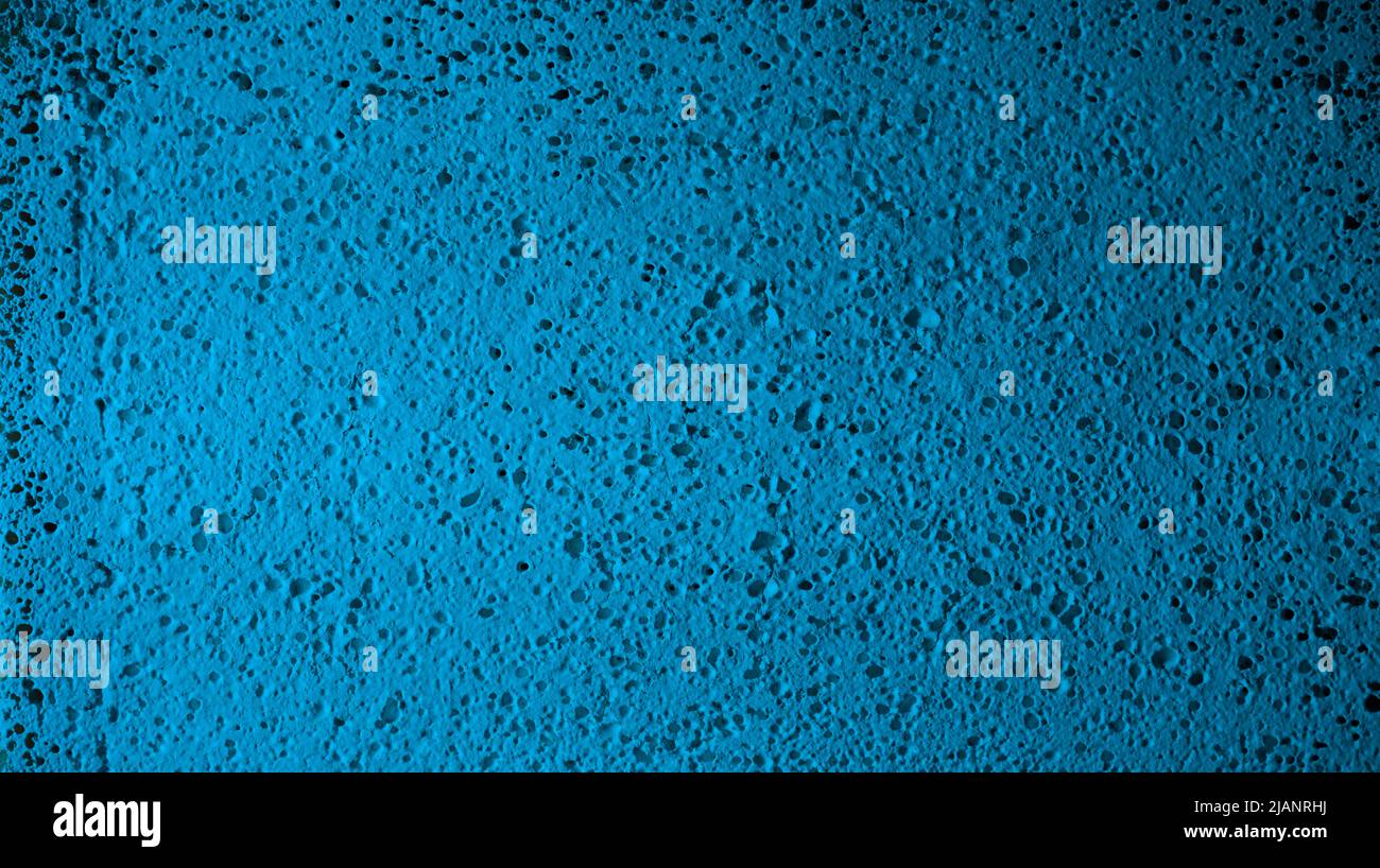 Gros plan sur une surface texturée turquoise. Fond de mur perforé bleu clair usé. Banque D'Images