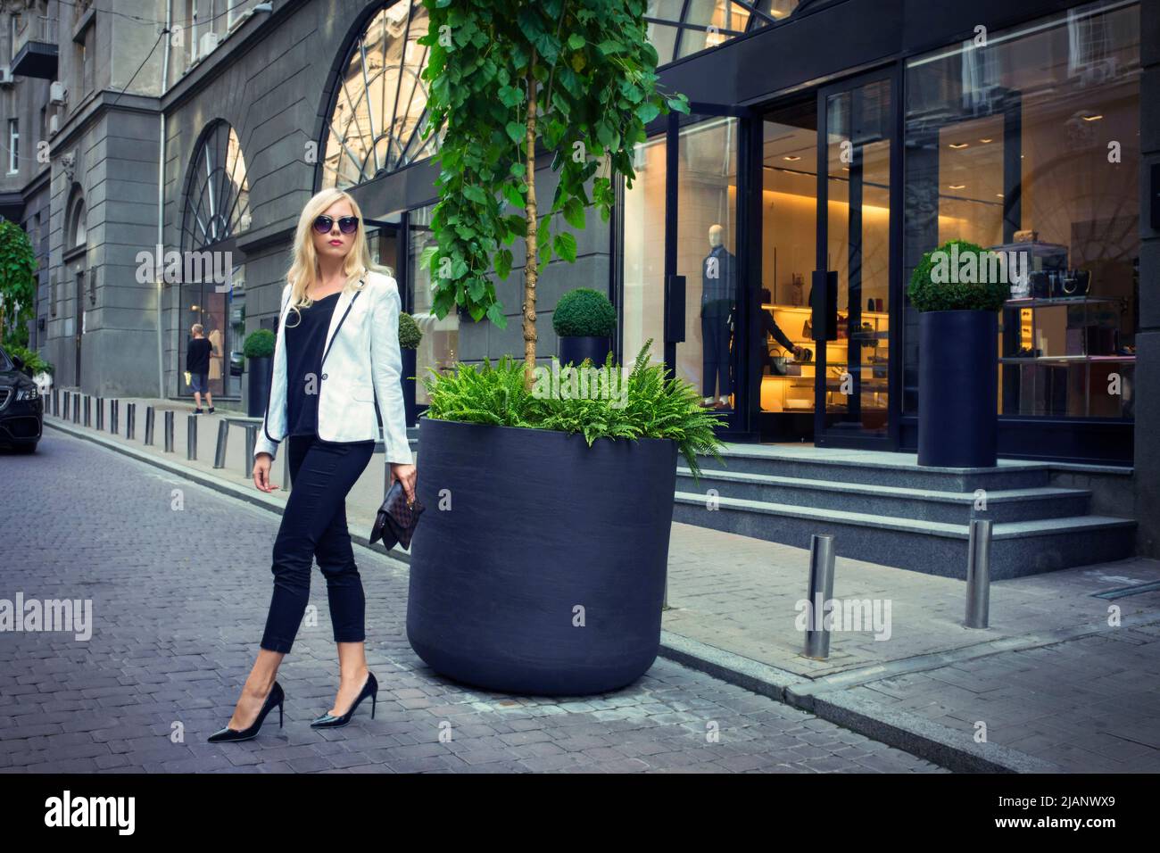 La jeune fille belle en lunettes de soleil sur la rue de la ville. Banque D'Images