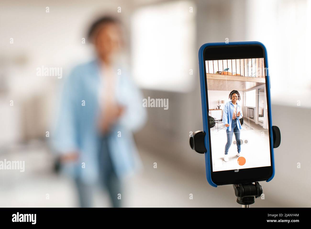 Une femme noire gaie filmant des vidéos de danse sur un téléphone portable Banque D'Images