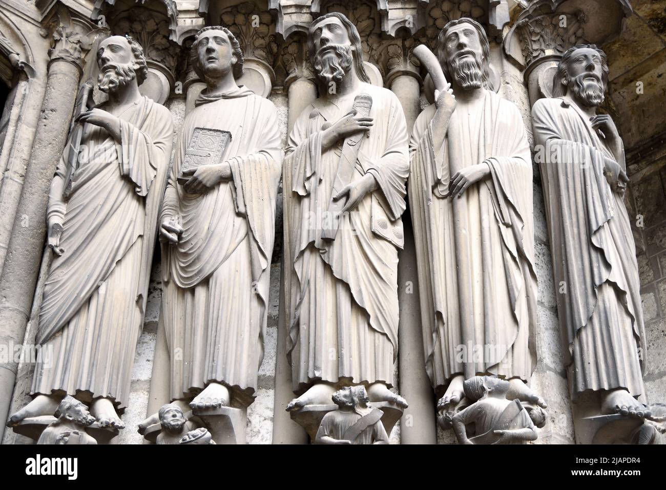 Statues de jamb, Cathédrale de Chartres, à environ 80 km au sud-ouest de Paris, France. Ces statues de jambe sont sur le côté droit du portail central du porche sud. De gauche à droite : Saint-Paul tenant l'épée qui l'a tué, debout au-dessus de l'empereur Néron; Saint-Jean le Divin tenant un livre; Saint-Jacques le Grand au-dessus de Hérode Agrippa; Saint-Jacques le petit tenant le club avec lequel il a été battu à mort; Saint-Bartholomée. Saint-Jacques le plus grand porte une pochette de pèlerin avec des coquilles Saint-Jacques, un symbole porté par les pèlerins qui ont voyagé à son sanctuaire à Saint-Jacques-de-Compostelle. Banque D'Images