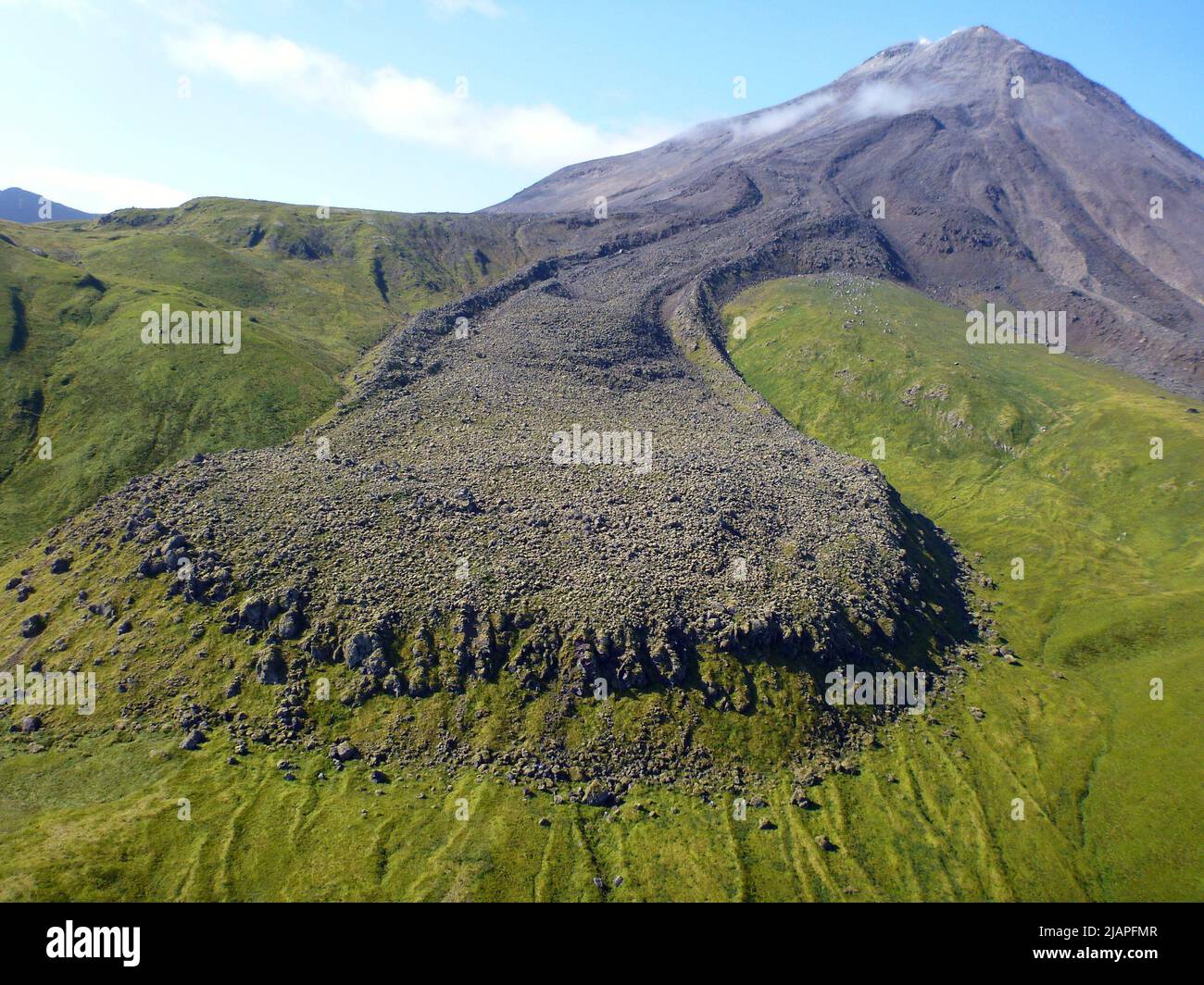 Le volcan Kanaga, l'un des membres les plus au sud de la chaîne des îles Aléoutiennes. Au premier plan se trouve une vue d'un écoulement de lave d'un événement 1906. Selon les documents, un trappeur vivant sur l'île en 1906 a connu plusieurs tremblements de terre et a été témoin d'un déversement de lave sur les côtés est et ouest du cône. Ê une version optimisée d'une image de la Commission géologique des États-Unis. Crédit: USGS/M.Combs Banque D'Images