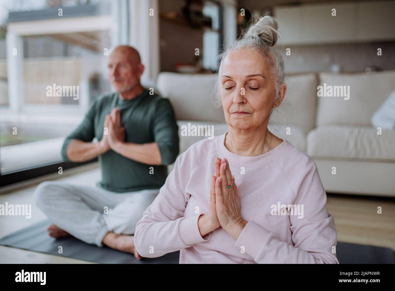 Couple senior faisant de l'exercice de relaxation ensemble à la maison. Banque D'Images