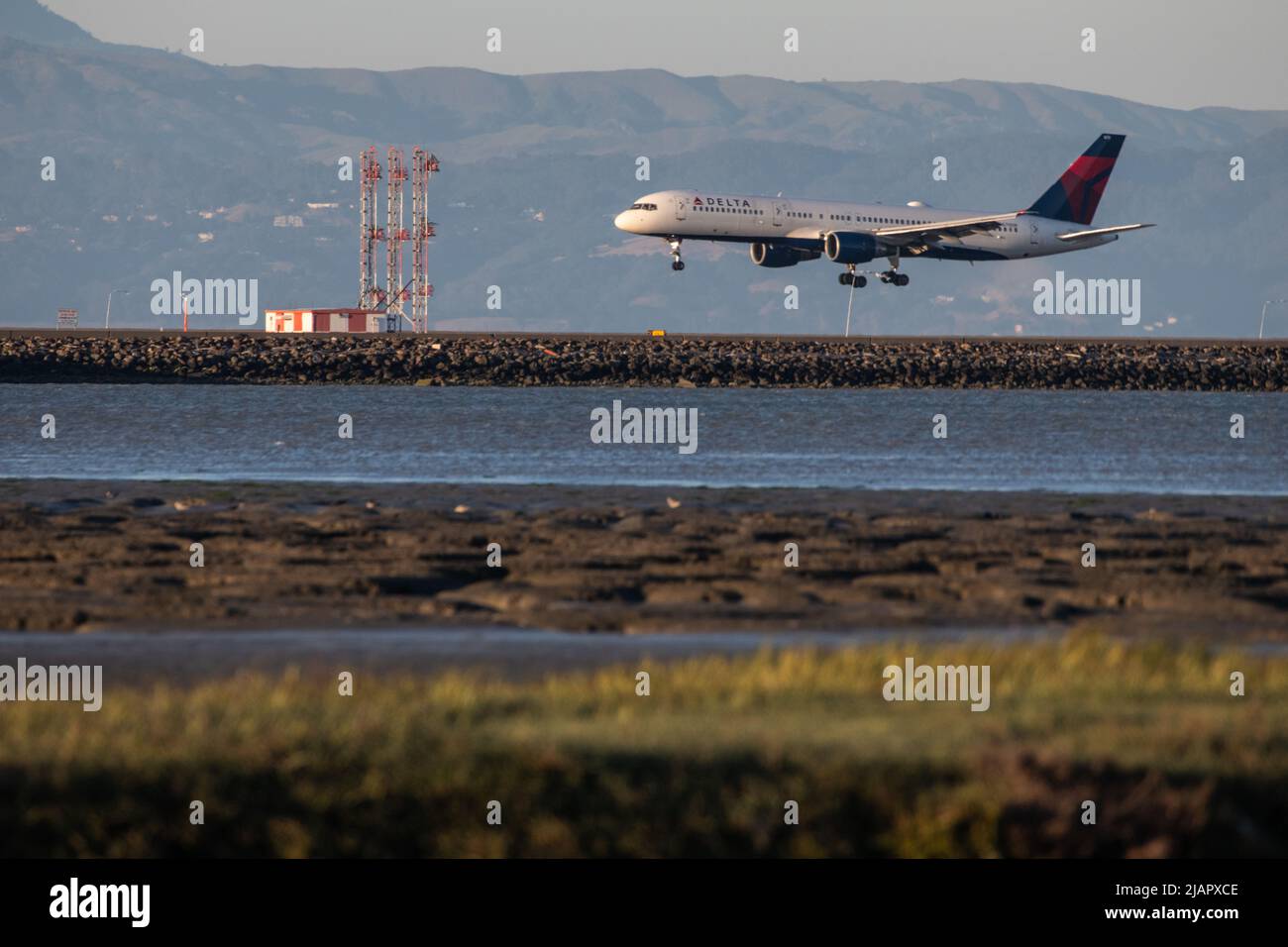 Un avion de la compagnie aérienne Delta arrive pour un atterrissage sur la piste de l'aéroport international de San Francisco (SFO) dans la région de Bay en Californie. Banque D'Images