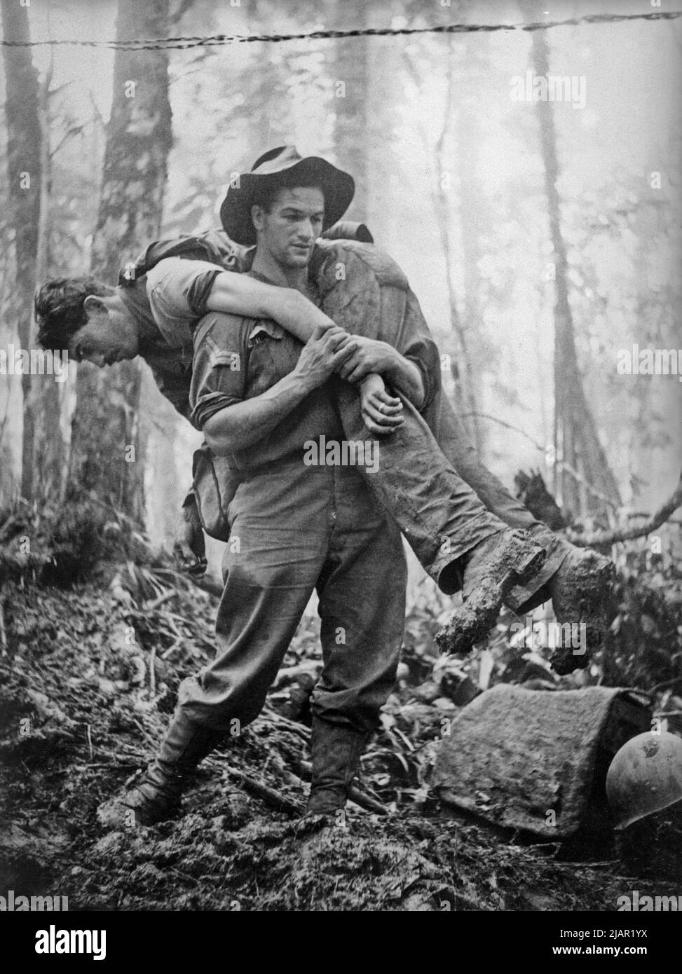 Le porte-civière australien, le caporal Leslie Allen du bataillon d'infanterie 2/5th, sauve un soldat américain pendant les combats contre les Japonais sur le mont Tambu, pendant la Seconde Guerre mondiale vers. 1943 Banque D'Images