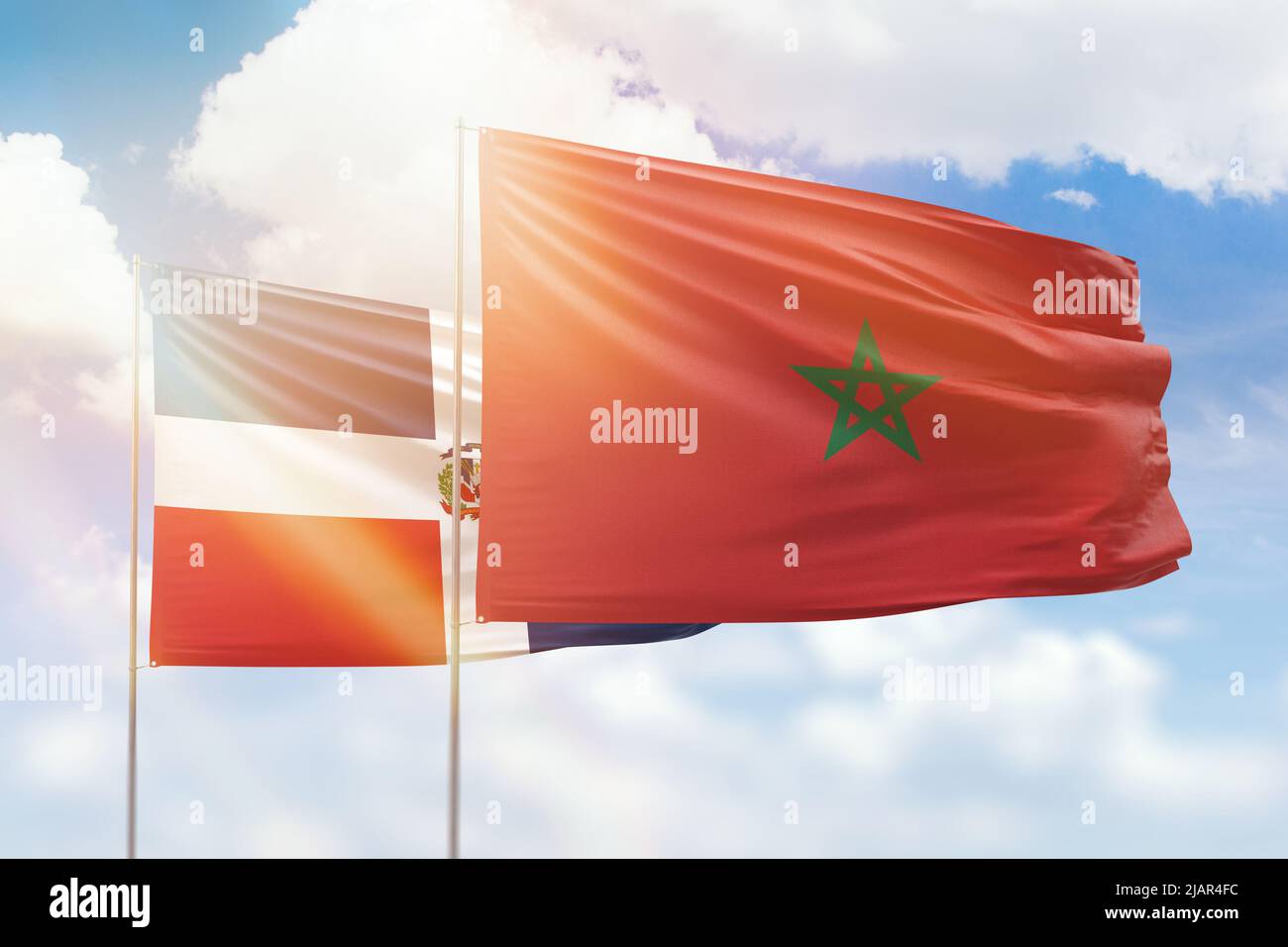 Ciel bleu ensoleillé et drapeaux du maroc et de la république dominicaine Banque D'Images