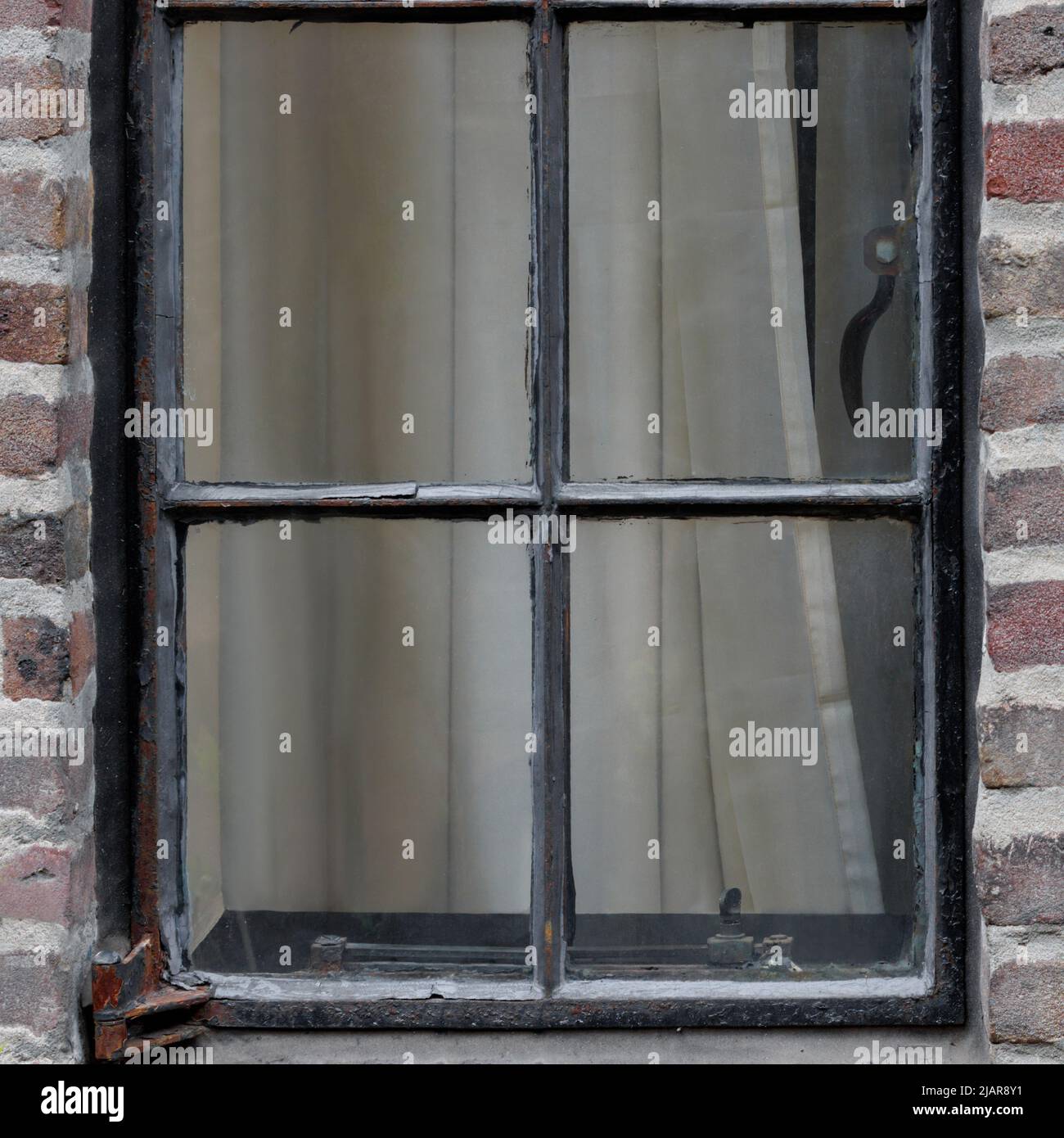 vue extérieure de la fenêtre antique de caisse dans un vieux bâtiment en brique rouge, fermé avec des rideaux tirés, format carré Banque D'Images