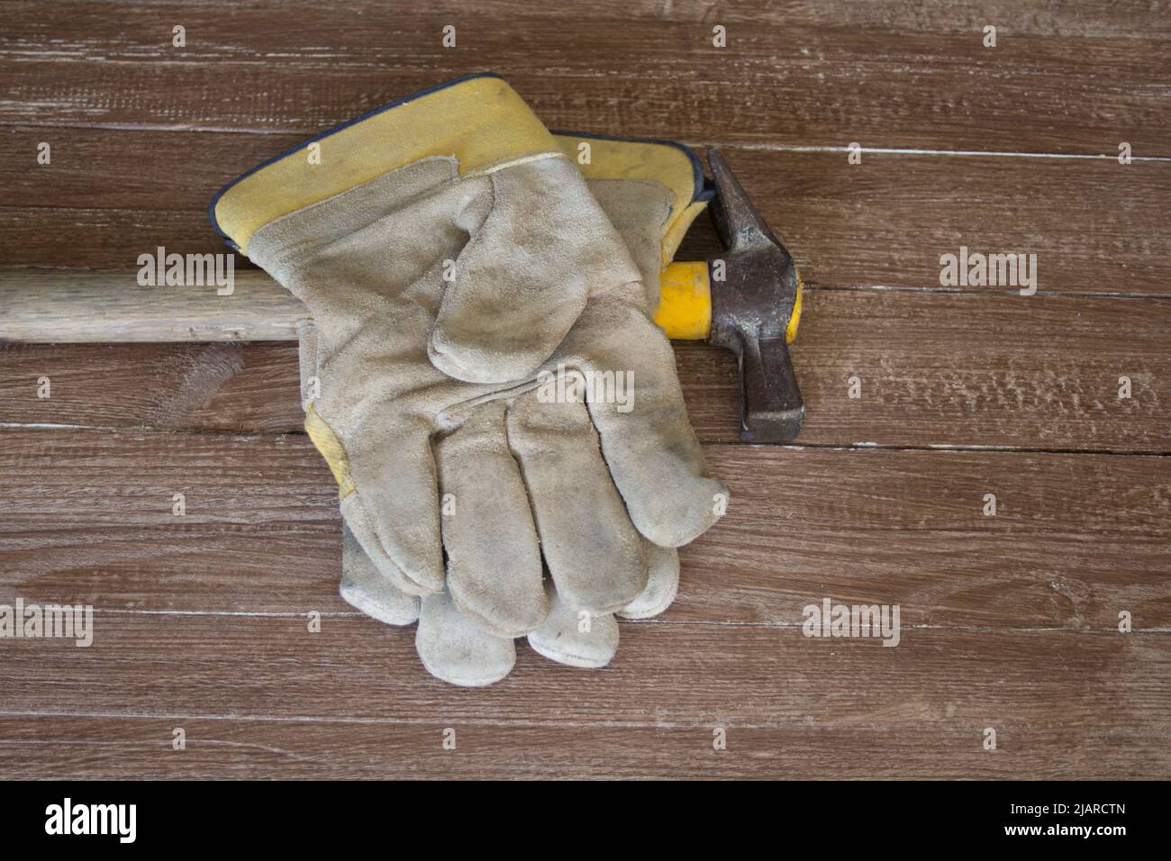 Image d'une paire de gants de travail et d'un marteau de maçon. Représentation des accidents au travail Banque D'Images