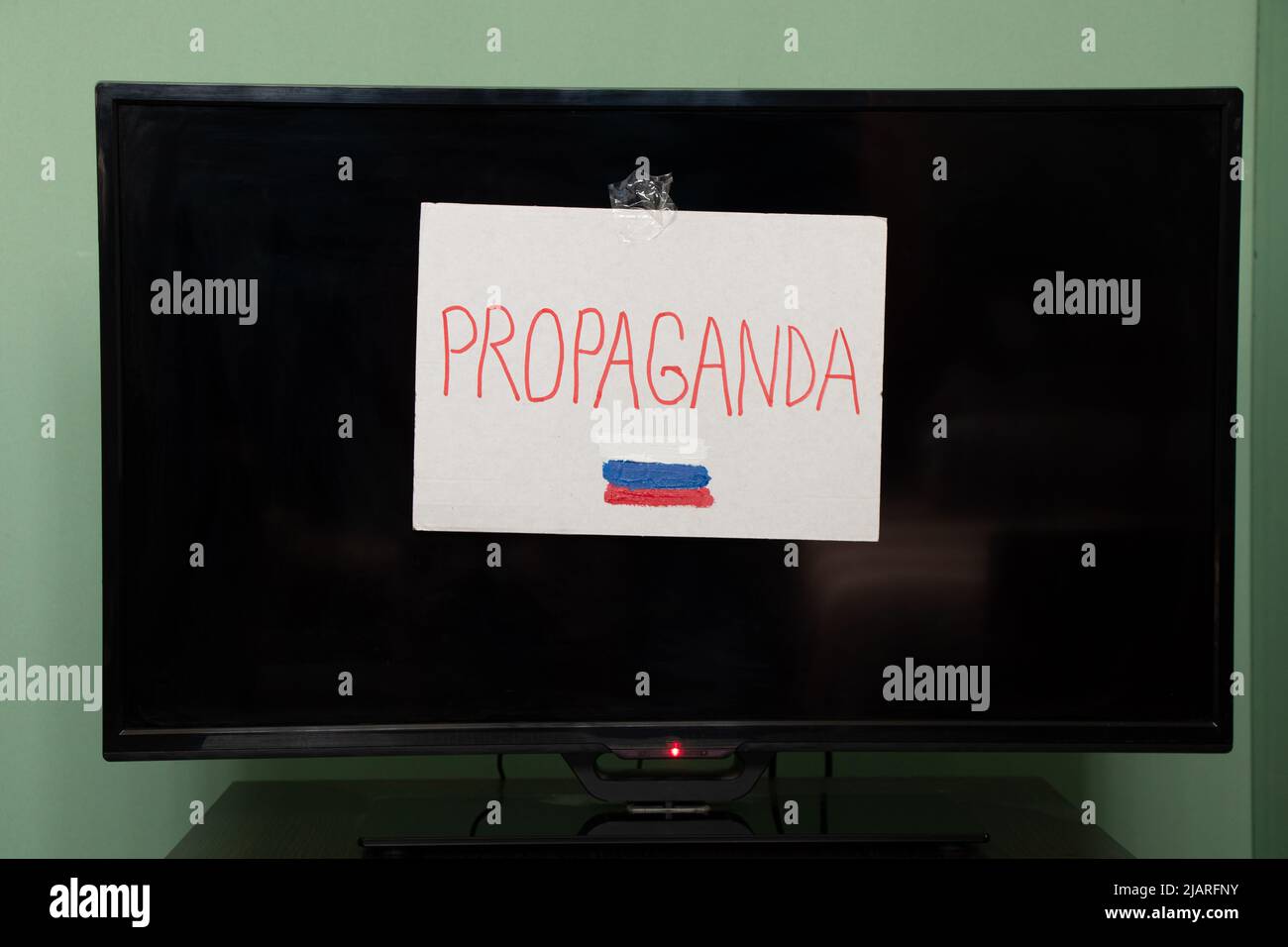 Le mot propagande et le drapeau de la Russie est écrit sur une plaque qui est accroché à la télévision, propagande russe être prudent, arrêter la guerre en Ukraine Banque D'Images