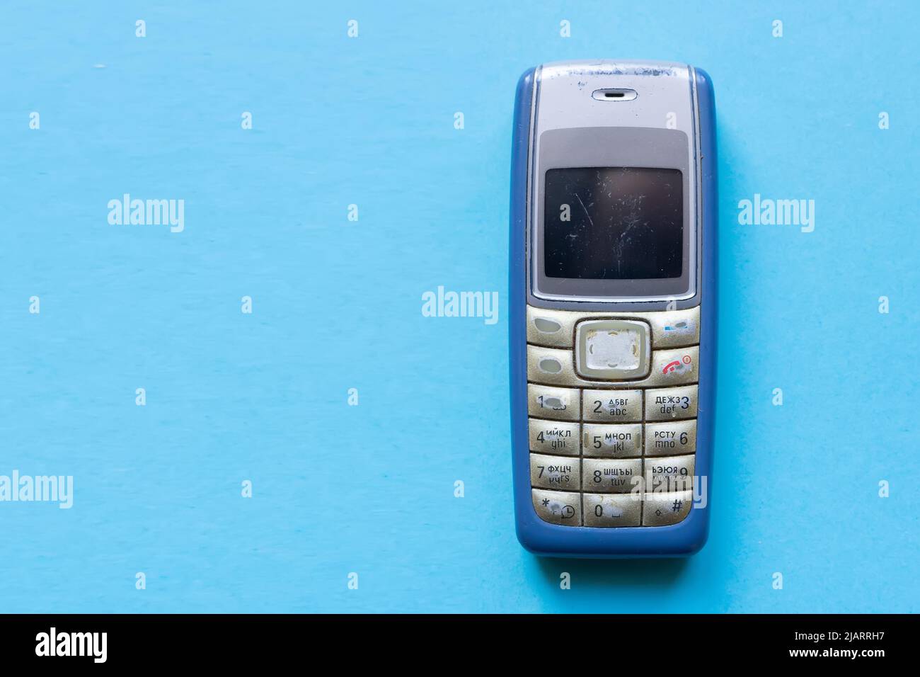 Ancien téléphone portable à bouton bleu sur fond bleu. Banque D'Images