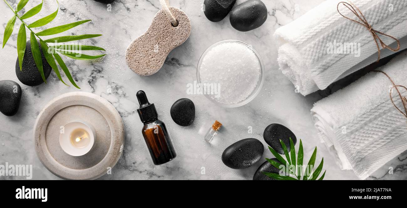 produits de soins du spa - pierres chaudes massantes avec sel et huiles sur une table en marbre. bannière vue du dessus Banque D'Images