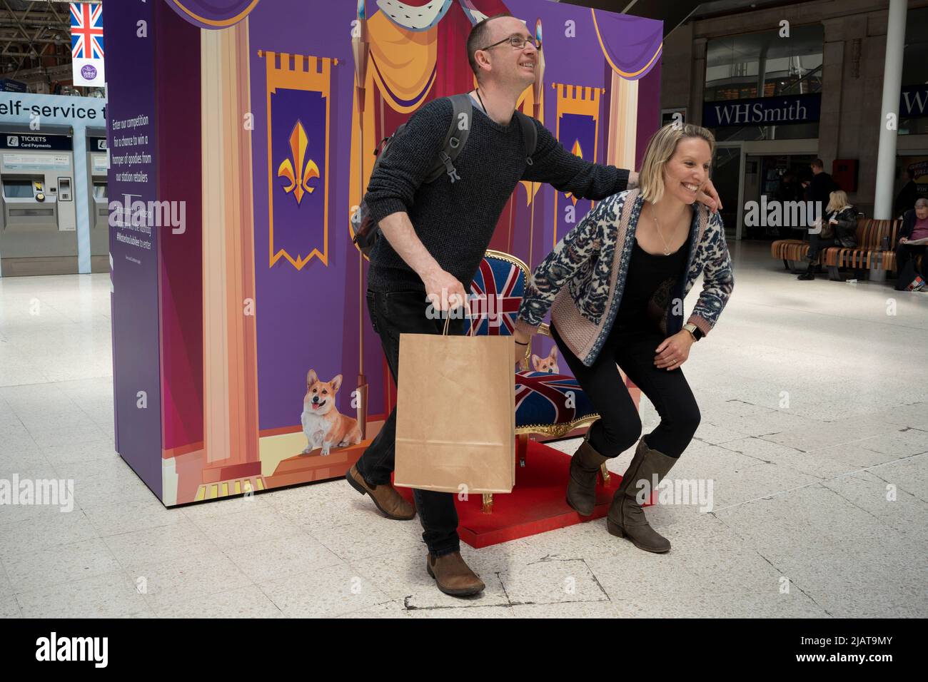 Un passager de chemin de fer aime s'asseoir sur un trône sur le hall de la gare de Waterloo alors que les préparatifs se poursuivent pour les célébrations du Jubilé de platine de la Reine dans la capitale, le 31st mai 2022, à Londres, en Angleterre. La reine Elizabeth II est sur le trône du Royaume-Uni depuis 70 ans, le monarque le plus longtemps au service de l'histoire anglaise et les drapeaux de l'Union Jack peuvent être vus partout dans le pays dans la semaine précédant le week-end du Jubilé. Banque D'Images