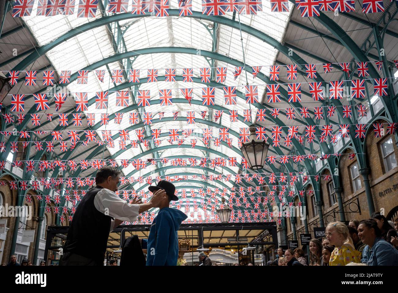 Un animateur de rue se produit devant les foules à Covent Garden alors que les préparatifs se poursuivent pour les célébrations du Jubilé de platine de la Reine dans la capitale, le 31st mai 2022, à Londres, en Angleterre. La reine Elizabeth II est sur le trône du Royaume-Uni depuis 70 ans, le monarque le plus longtemps au service de l'histoire anglaise et les drapeaux de l'Union Jack peuvent être vus partout dans le pays dans la semaine précédant le week-end du Jubilé. Banque D'Images