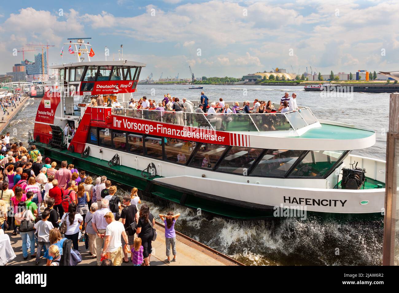 Hambourg, Allemagne - 12 juillet 2011 : Port de Hambourg. Tour en bateau se tirant hors de l'amarrage tandis qu'une grande foule attend le bateau suivant pour arriver. Banque D'Images