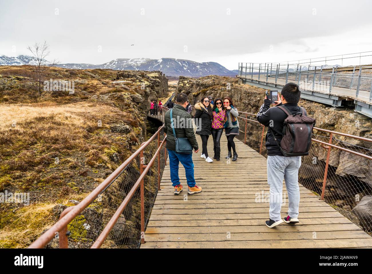 La région de Þingvellir fait partie d'une zone de rift qui traverse l'Islande et se trouve sur les limites de la plaque tectonique de la dorsale médio-atlantique. Les failles et fissures dans cette zone illustrent la perturbation de la croûte terrestre. Un bon endroit pour une photo souvenir dans le fossé étroit entre l'Europe et l'Amérique. Þingvellir, Islande Banque D'Images