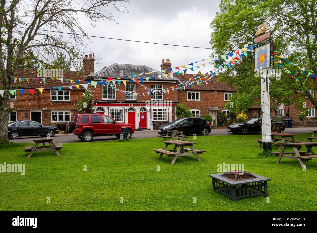 Le Sun Inn dans le village de Dunsfold, Surrey, Angleterre, Royaume-Uni, avec des banderoles colorées Banque D'Images