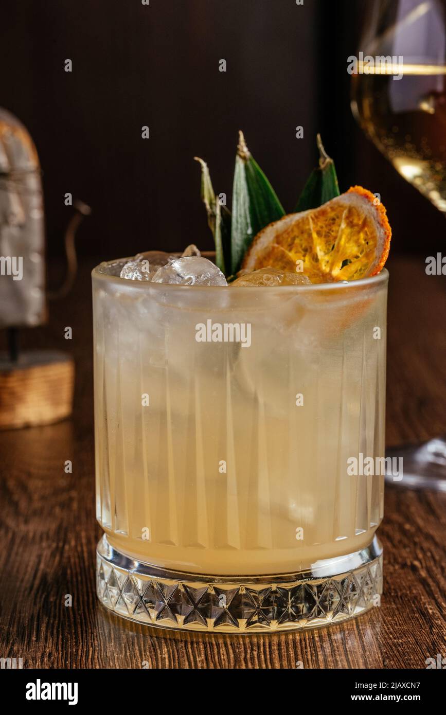 le cocktail est servi avec des feuilles de citron et d'ananas séchées Banque D'Images