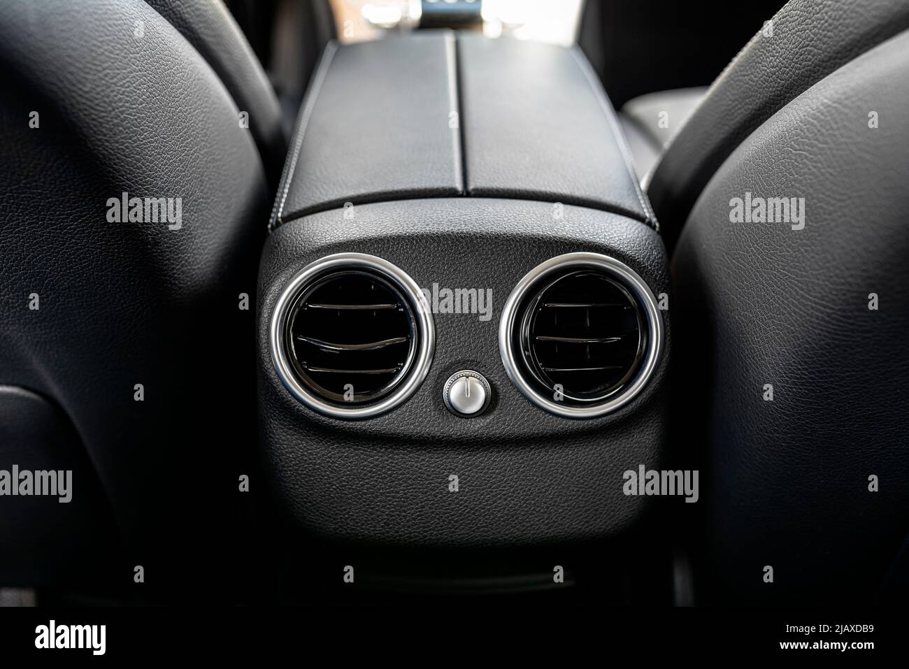 L'intérieur d'une voiture de tourisme moderne avec deux entrées d'air rondes visibles dans l'accoudoir à l'arrière. Banque D'Images