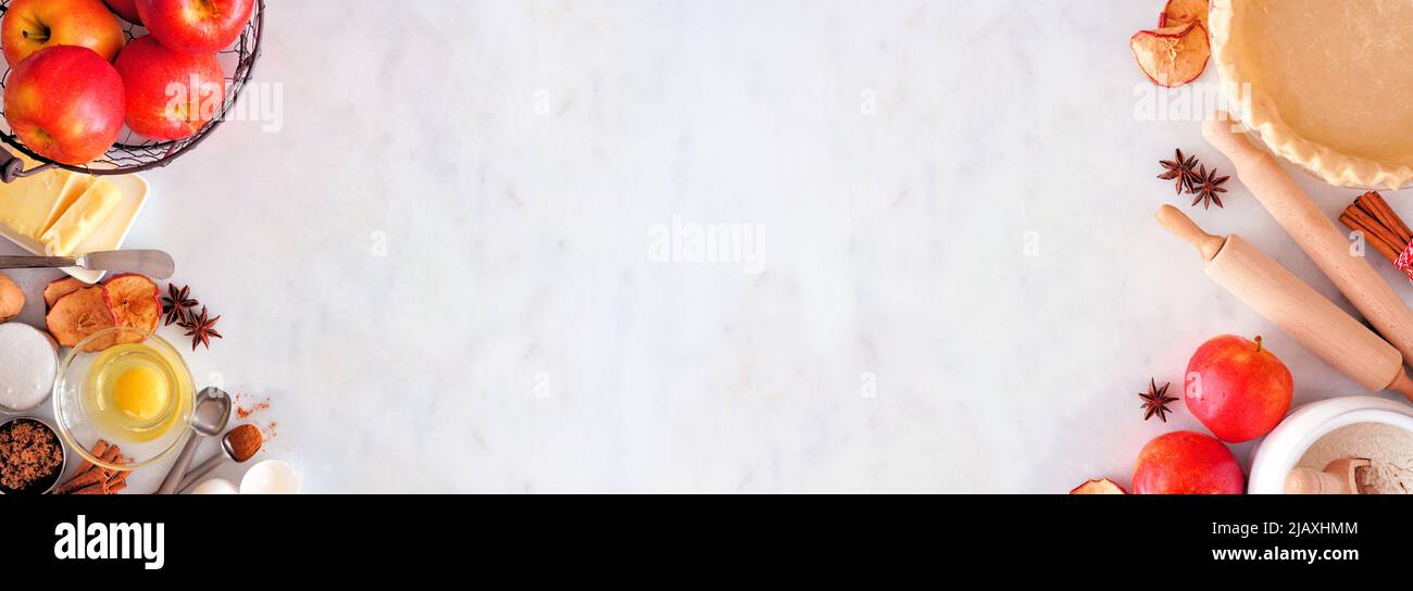 La double bordure de cuisson d'automne avec les ingrédients de la tarte aux pommes. Vue ci-dessus sur un arrière-plan de bannière en marbre blanc avec espace de copie. Banque D'Images