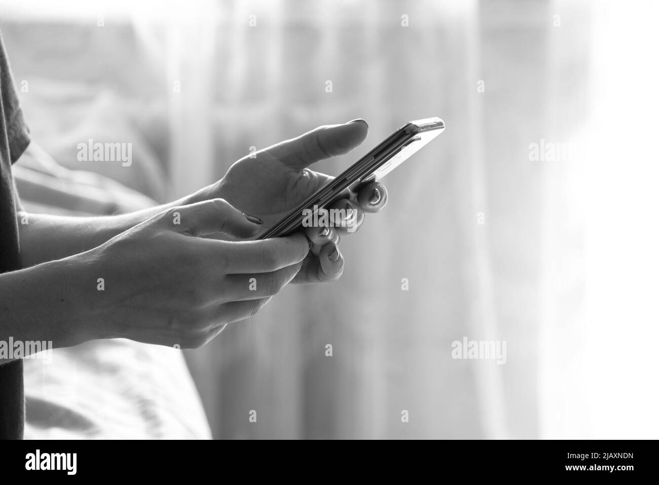 La jeune fille tient un téléphone à la maison, la communication en ligne sur le téléphone, un appel sur un téléphone mobile Banque D'Images
