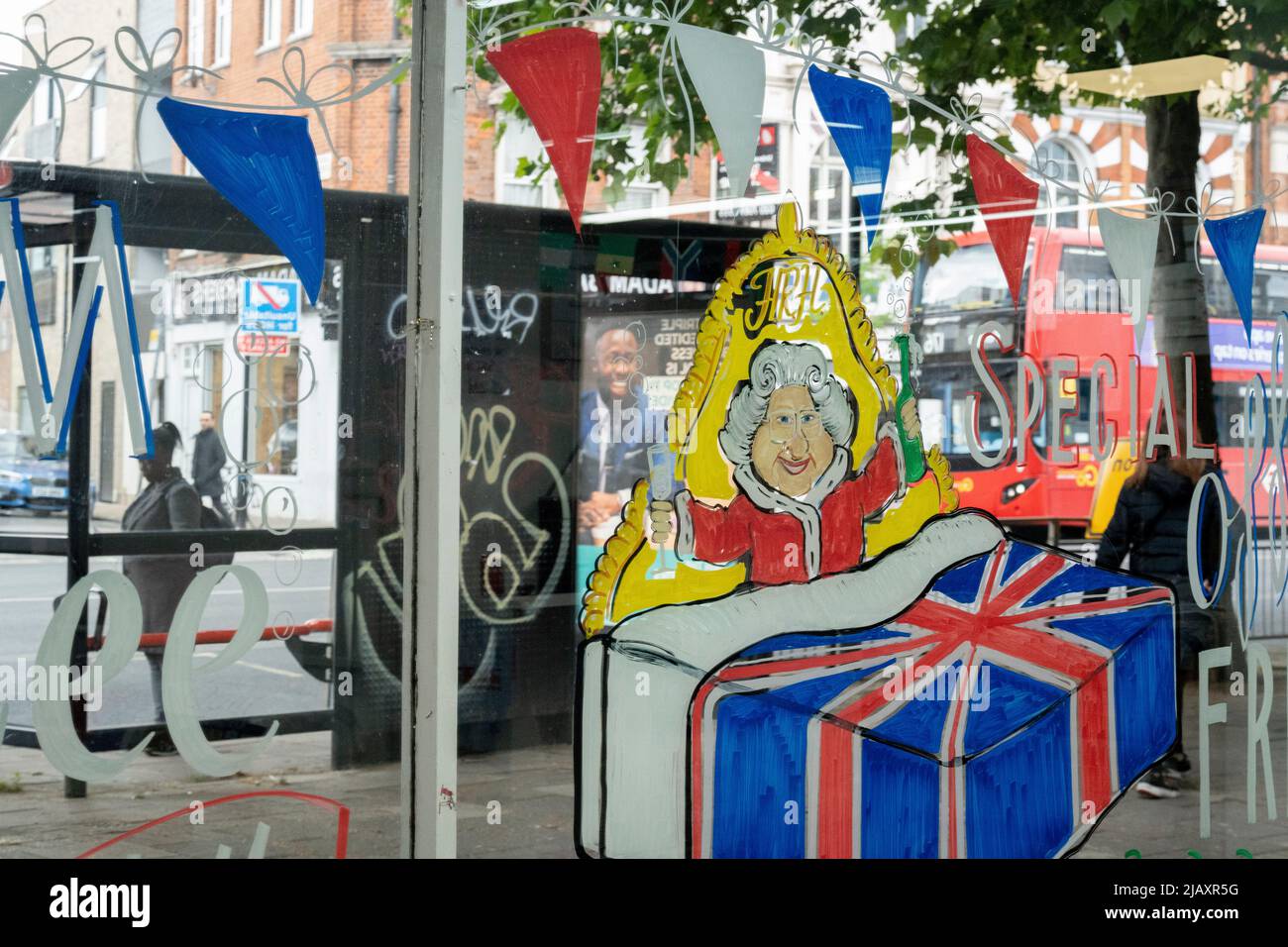 Une peinture montrant la Reine au lit est sur la fenêtre d'un magasin de lit et de meubles sur la route Walworth dans le sud de Londres, le 1st juin 2022 à Londres, Angleterre. La reine Elizabeth II est sur le trône du Royaume-Uni depuis 70 ans, le monarque le plus longtemps au service de l'histoire anglaise et les drapeaux de l'Union Jack peuvent être vus partout dans le pays dans la semaine précédant le week-end du Jubilé. Banque D'Images