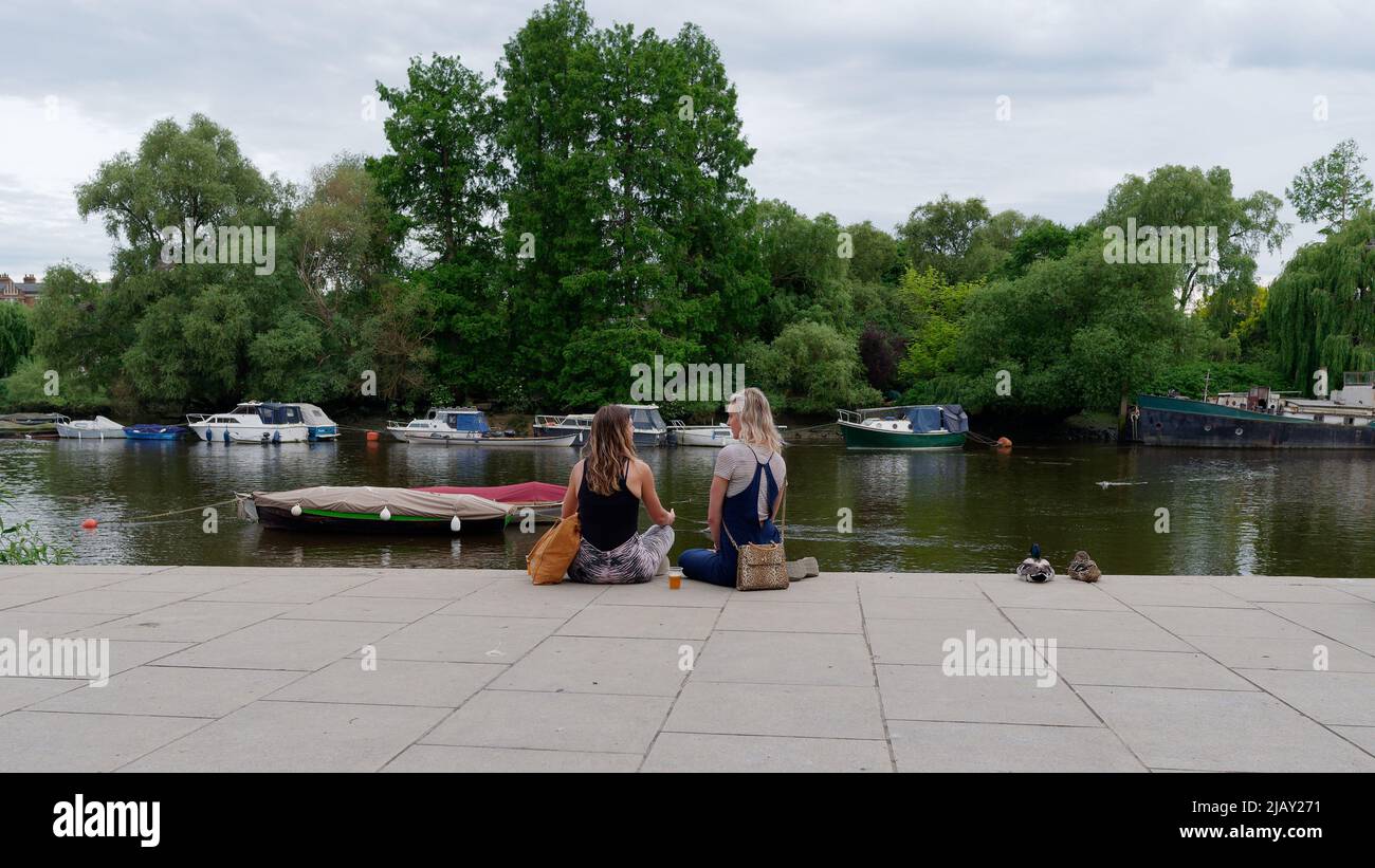 Richmond, Grand Londres, Angleterre, 18 mai 2022 : des amies qui s'assèdent et bavardent le long des rives de la Tamise. Banque D'Images