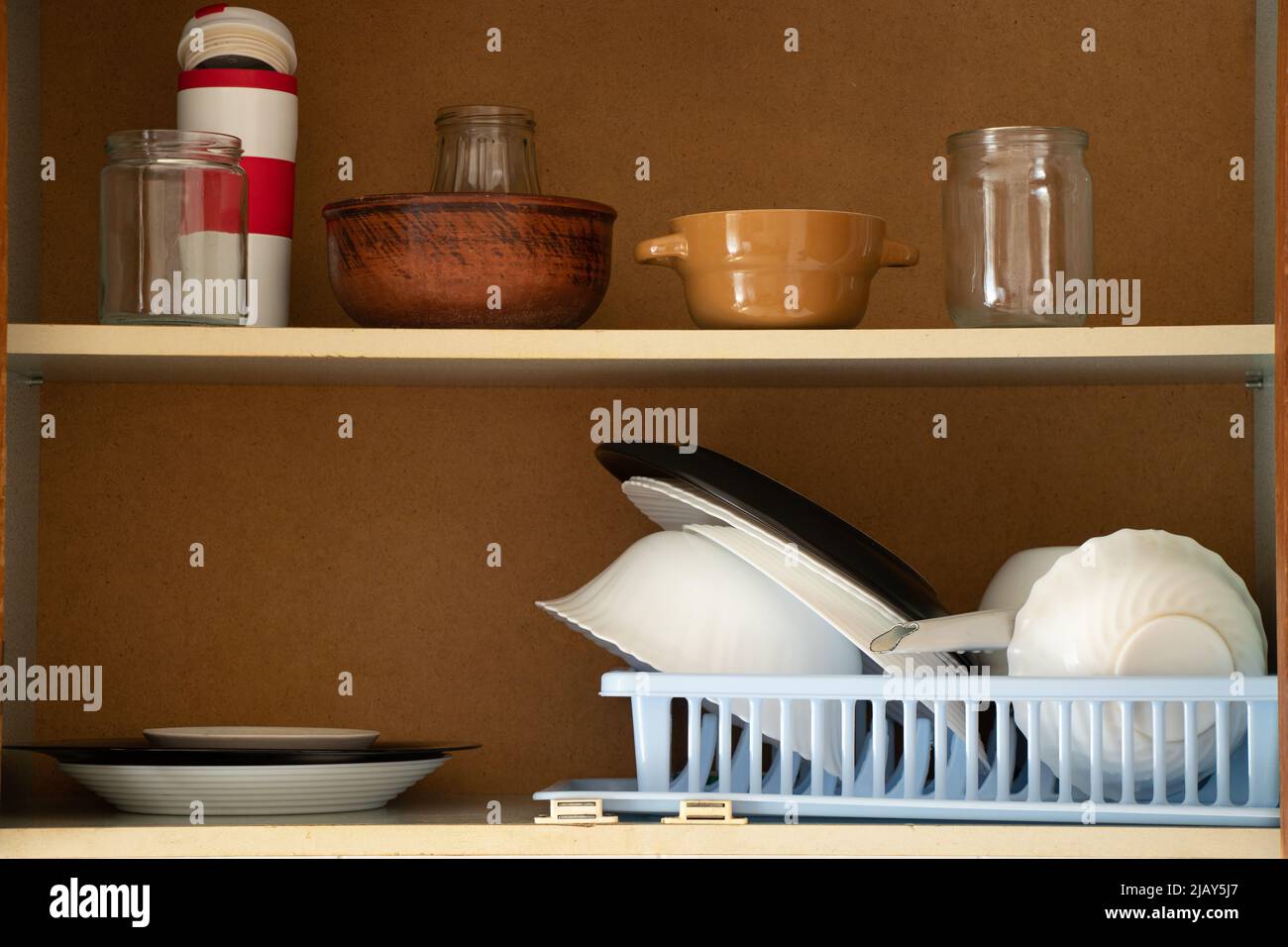 Armoire de cuisine ancienne avec ustensiles dans la cuisine dans l'appartement, plaques de cuisine sur les étagères dans l'armoire Banque D'Images