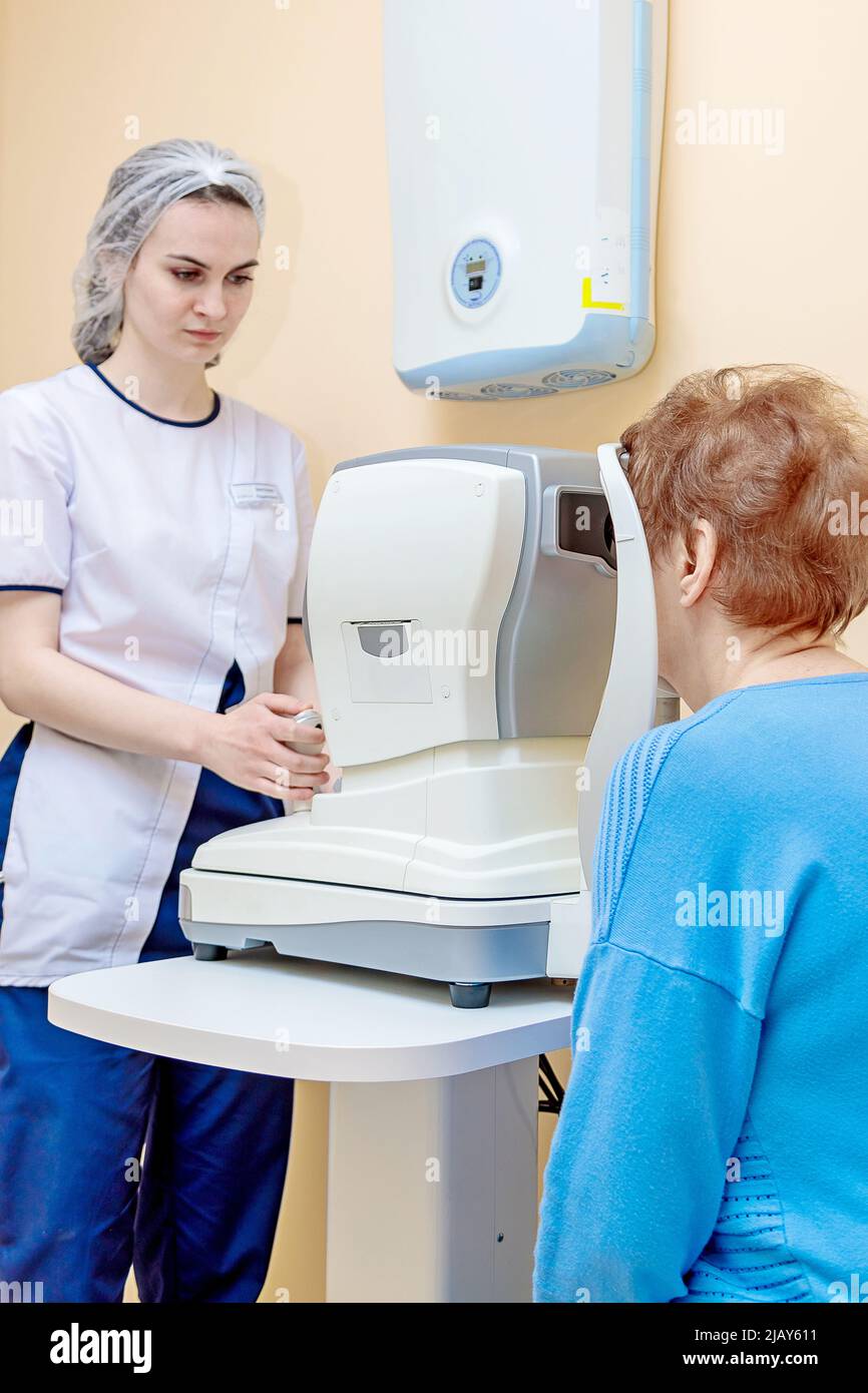 Une jeune optométriste examine les yeux d'un patient à l'aide d'un équipement moderne spécial. Banque D'Images