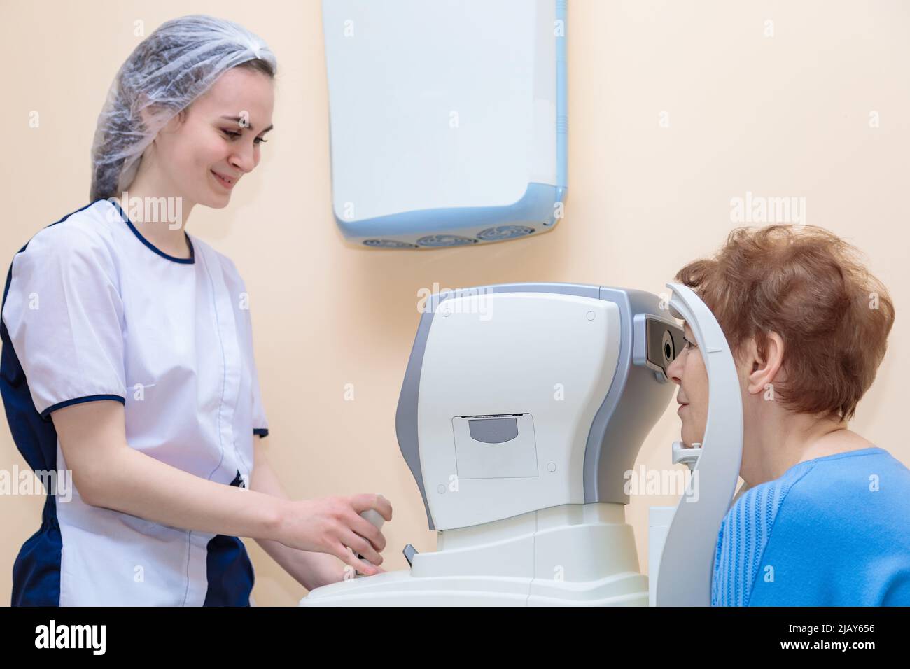 Une jeune optométriste examine les yeux d'un patient à l'aide d'un équipement moderne spécial. Banque D'Images