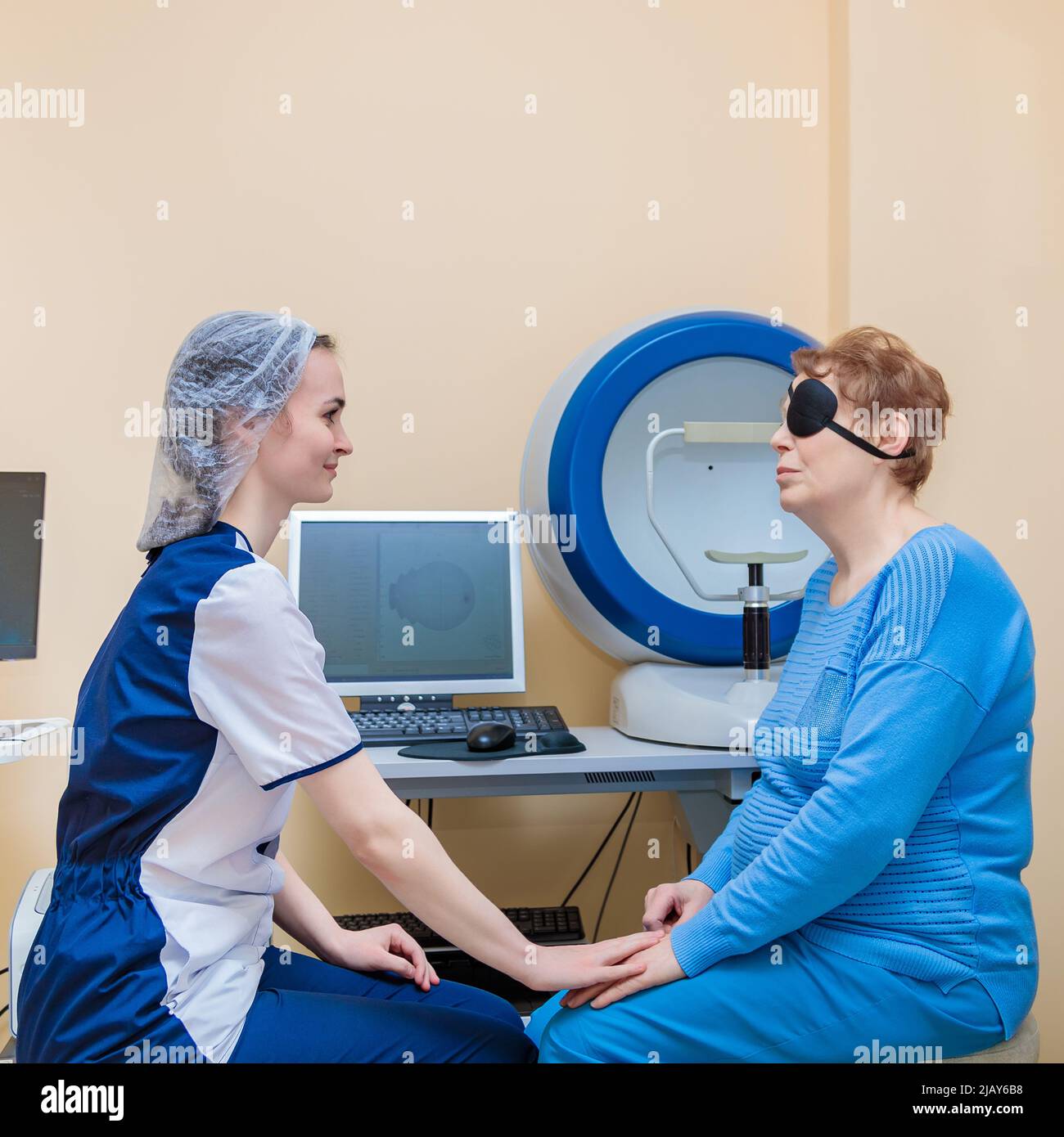 Une jeune optométriste examine les yeux d'un patient à l'aide d'un équipement moderne spécial. Banque D'Images