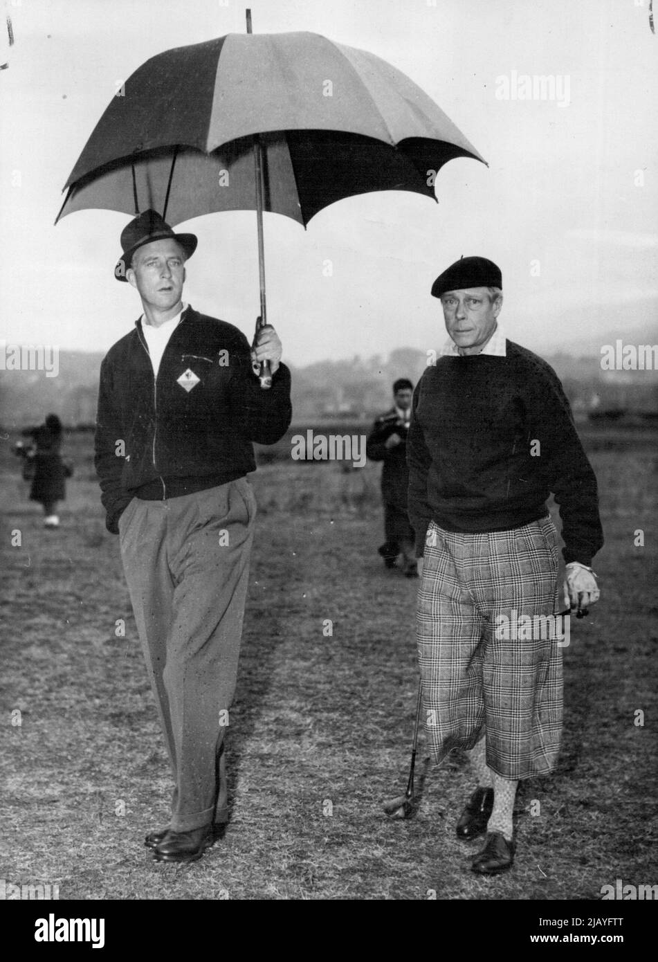 Refuge pour les chefs royaux : le roi Léopold de Belgique (à gauche) et le duc de Windsor partagent et ombrelle lors de leur quatrième match de golf au club de Mandelieu, près de Cannes, 1 janvier. Les deux jouaient avec la princesse de Réthy, épouse de Léopold et comte d'Arcangues. 3 février 1949. (Photo par photo de presse associée). Banque D'Images