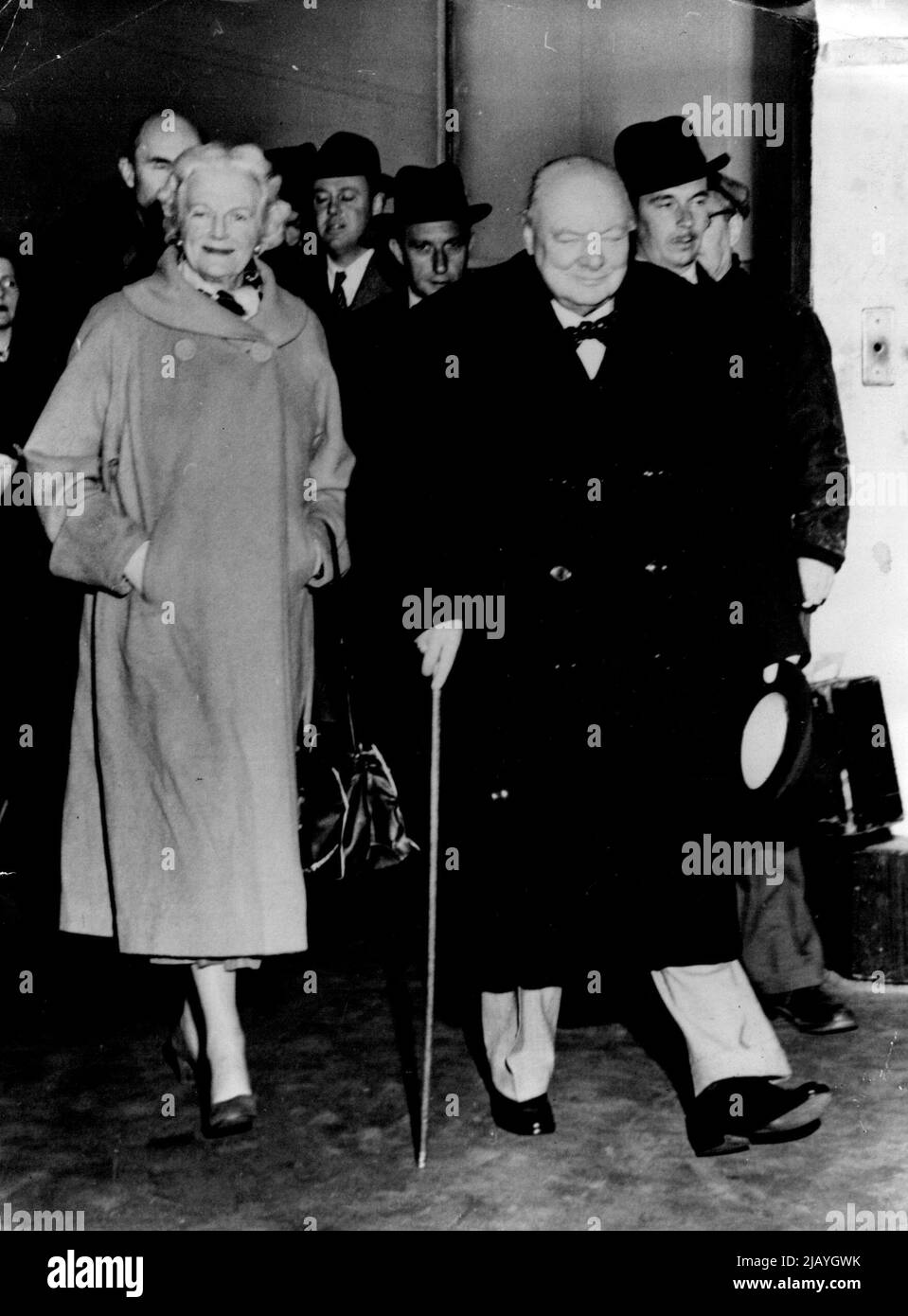 Le Churchill Beam : Un superbe Winston Churchill, premier ministre britannique, accompagné de Mme Churchill, se rend à pied au gangway à New York pour monter à bord du Cunarder 'Queen Mary' pour la Grande-Bretagne après ses vacances en Jamaïque. M. Churchill doit se faire à Londres jeudi matin. 27 janvier 1953. (Photo de Reuterphoto). Banque D'Images