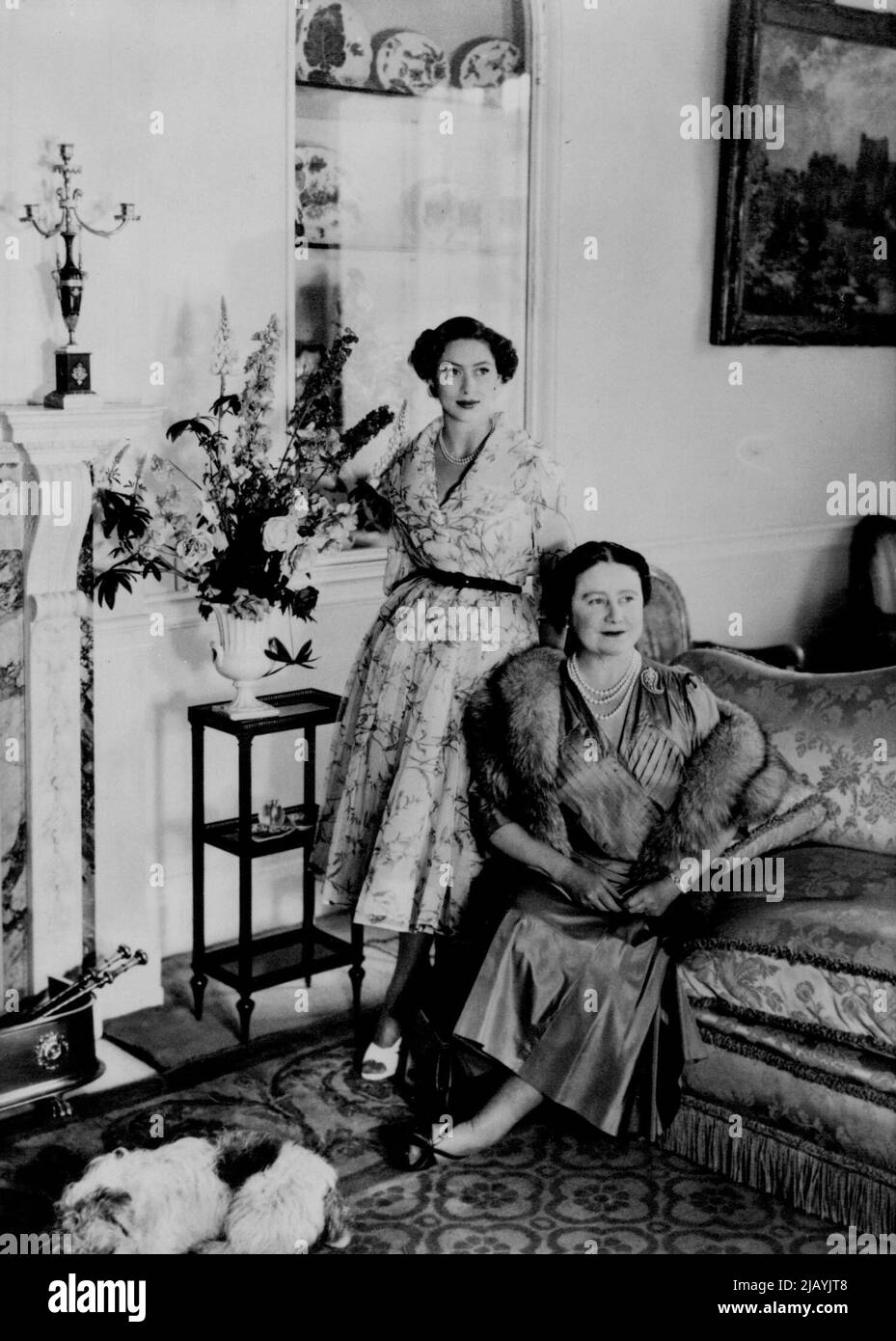 Portrait d'anniversaire de la princesse Margaret - ce portrait de la princesse Margaret et de sa mère, la reine Elizabeth la mère de la reine, a été fait dans la salle du matin à Clarence House, Londres, en particulier pour l'anniversaire de la princesse de 21 août en 24th. La princesse Margaret porte une robe de chatterend blanc d'organza avec des fleurs de couleur violette. La Reine mère porte une robe de soie bleu-gris, avec une fourrure de renard gris. PET Sealyham Puppy, « Pippin. » Le photographe était Cecil Beaton. La princesse Margaret, sœur de la reine Elizabeth, vit à la maison Clarence avec la reine mère. Clarence House est près de Buckingham P. Banque D'Images