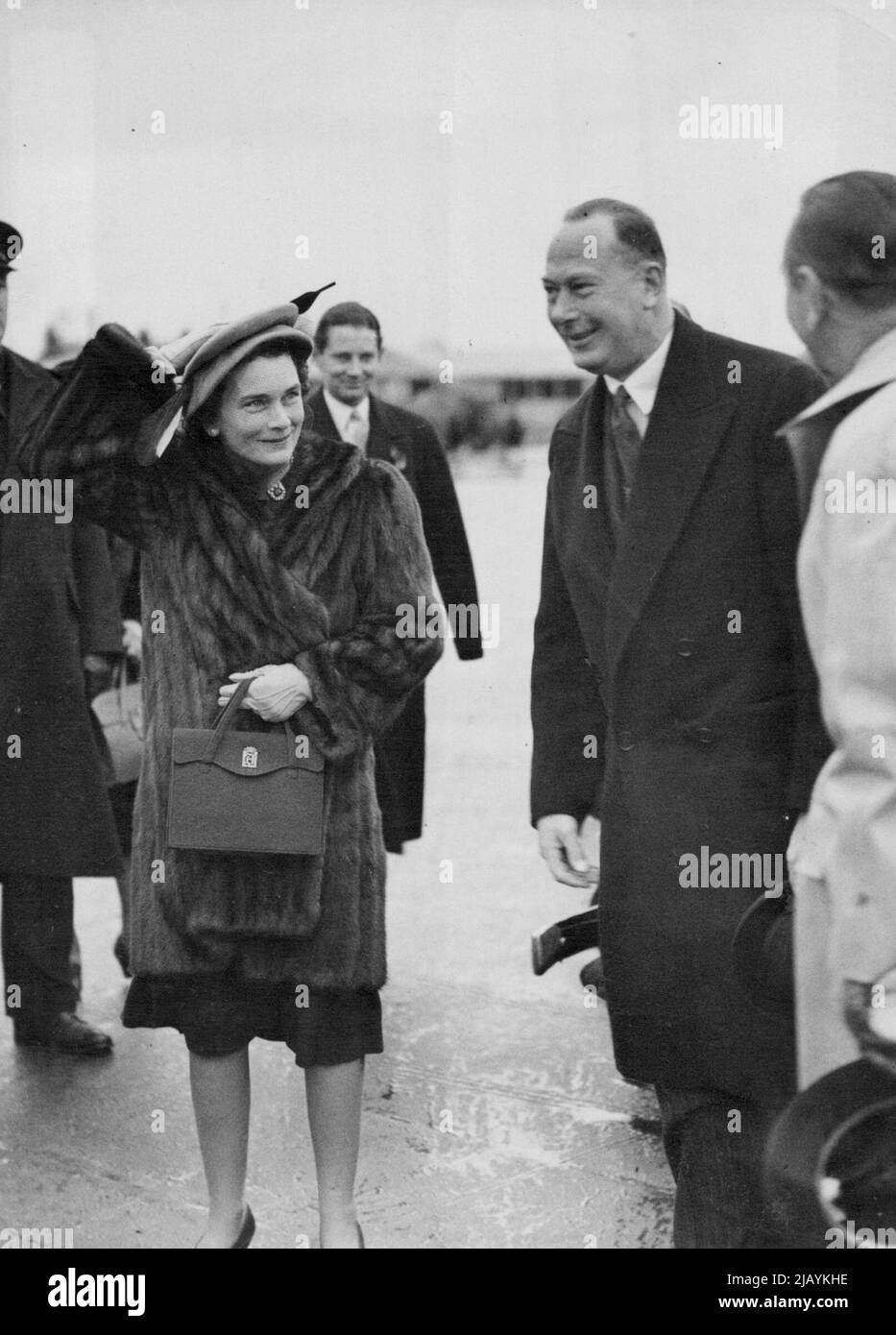 Duc et duchesse de Gloucester Fly à Malte -- le duc et la duchesse de Gloucester à l'aéroport de Londres, avant le vol à Malte. La duchesse tient son chapeau, à cause du vent fort. Le duc et la duchesse de Gloucester ont quitté l'aéroport de Londres, Heathrow, pour un vol vers Malte, où le duc doit ouvrir la Législature de Malte au Palais de la Valette, sur 10 novembre. 9 novembre 1947. Banque D'Images
