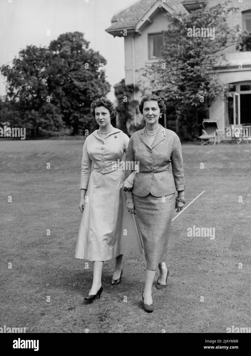 La duchesse et sa fille à la maison - bras dans le bras, la duchesse de Kent et la princesse Alexandra flânent dans le domaine de leur maison à Iver à jour. Ces photos " à la maison " de la jeune et attrayante princesse Alexandra et de sa mère tout aussi attrayante, la duchesse de Kent, ont été faites à leur résidence de campagne aux Coppins, Iver, Buckinghamshire, à ce jour (vendredi). En plus d'un bref séjour de finition à Paris, la princesse Alexandra a passé la plupart de ses 17½ années aux Coppins, la maison de sa mère depuis 1936. Depuis son retour de Paris, la princesse Alexander a été progressivement lancée dans le Banque D'Images
