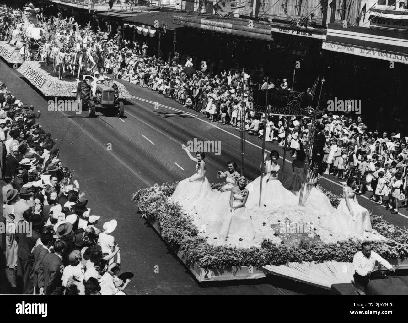 Le soleil brille aujourd'hui sur la scène florale de Melbourne. Ici, de jolies filles, vêtues de robes coulées de leurs flotteurs fleuris à la foule qui a rempli Swanston Street. 29 mars 1954. Banque D'Images