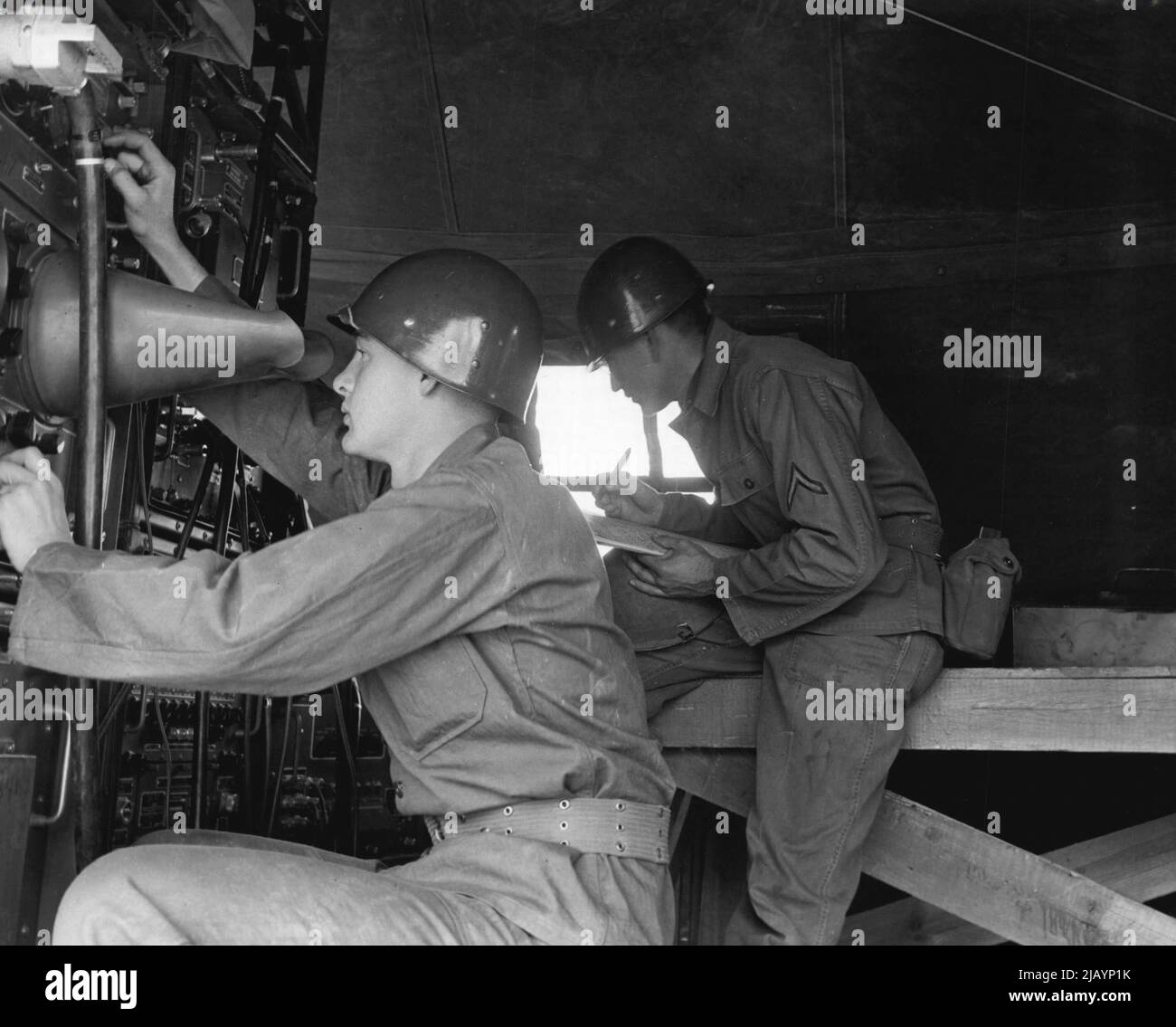 Regardez les Skies -- Pvt. Donald R. Carver, Topeka, Kansas, vérifie les plages cibles sur la portée de l'indicateur de position du plan de l'installation du radar tout en PFC. Marvin G. Bergmann Logs opérations. Les deux hommes sont membres de la batterie B, 531st bataillon d'artillerie antiaérienne, fort Bliss, Texas. 06 décembre 1954. (Photo par photo officielle de l'armée américaine). Banque D'Images