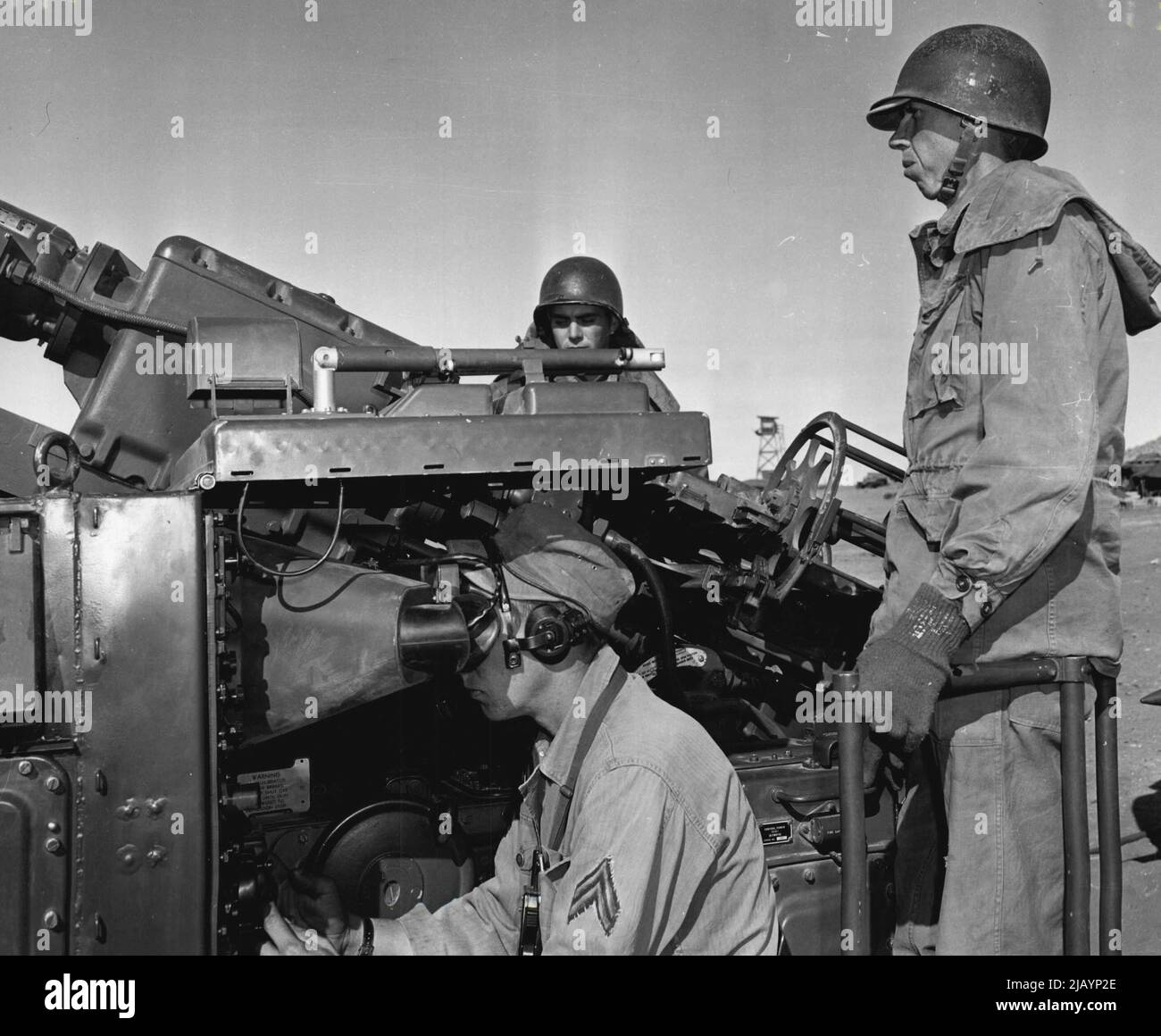 Regardez les Skies -- opérateur de radar Cpl. Joseph E. Brunner, Onaga, Kansas, règle son appareil de radar comme canons PFC. Eugene E. Keeney et Pvt. Gene E. ball, ville de Frederick, Missouri, se tenir à l'action. Ils sont membres de la batterie a, 531st anti Aircraft artillerie BN., fort Bliss, Texas. 06 décembre 1954. (Photo par photo officielle de l'armée américaine). Banque D'Images