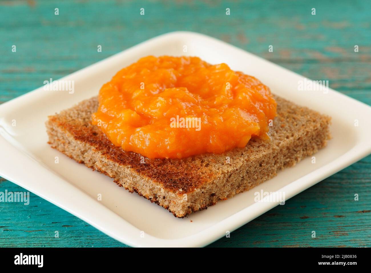 Citrouille maison et confiture d'orange sur pain de seigle toast sur plaque blanche carrée Banque D'Images