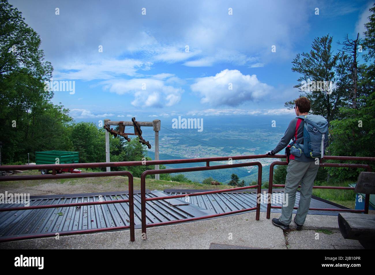 Femme âgée debout au point de vue sur le sommet de la colline et regardant la vallée Banque D'Images